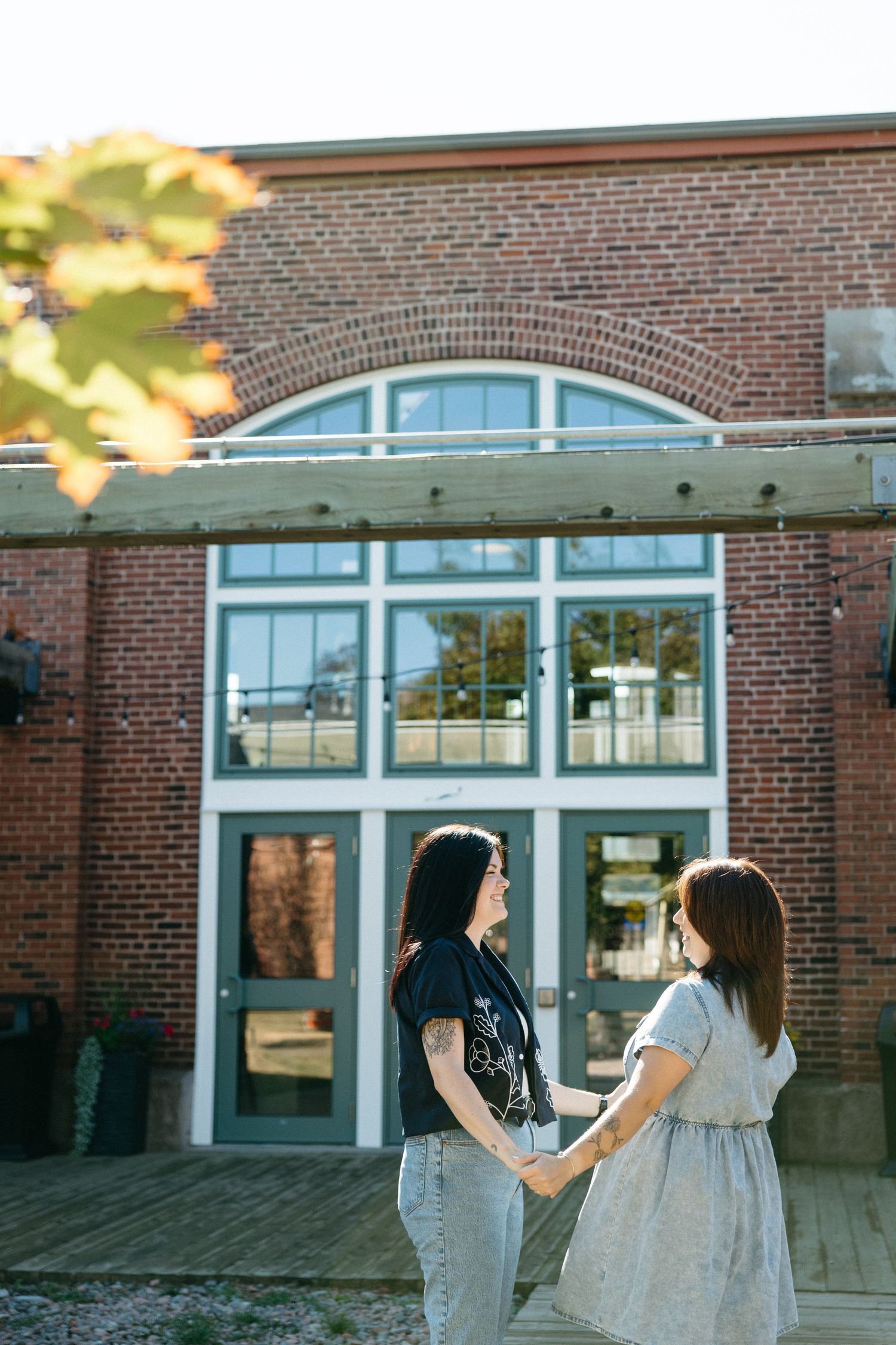 Brick building exterior with large windows and glass doors on a sunny day.