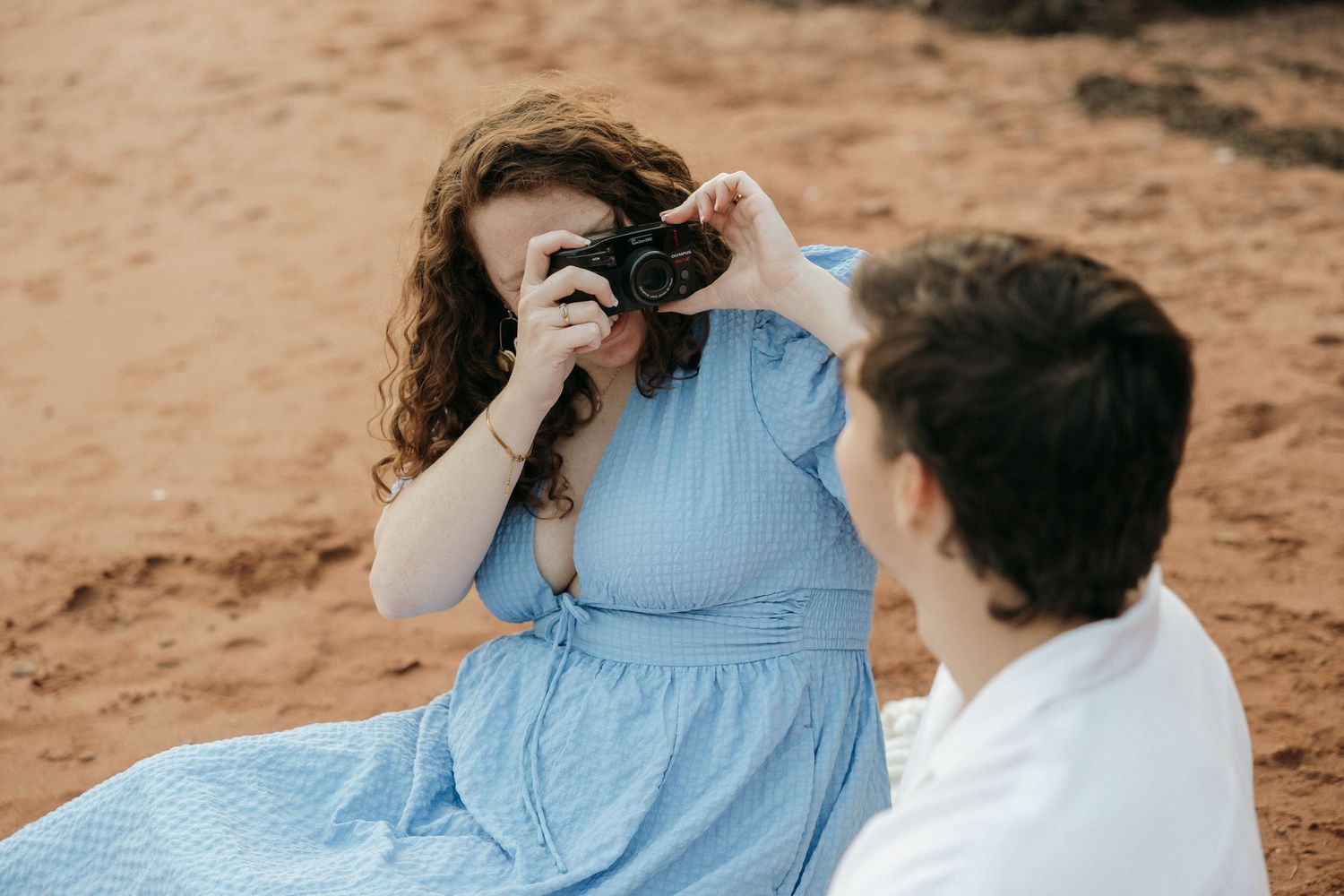 Intimate couple's portrait session captured against rustic red rock backdrop.