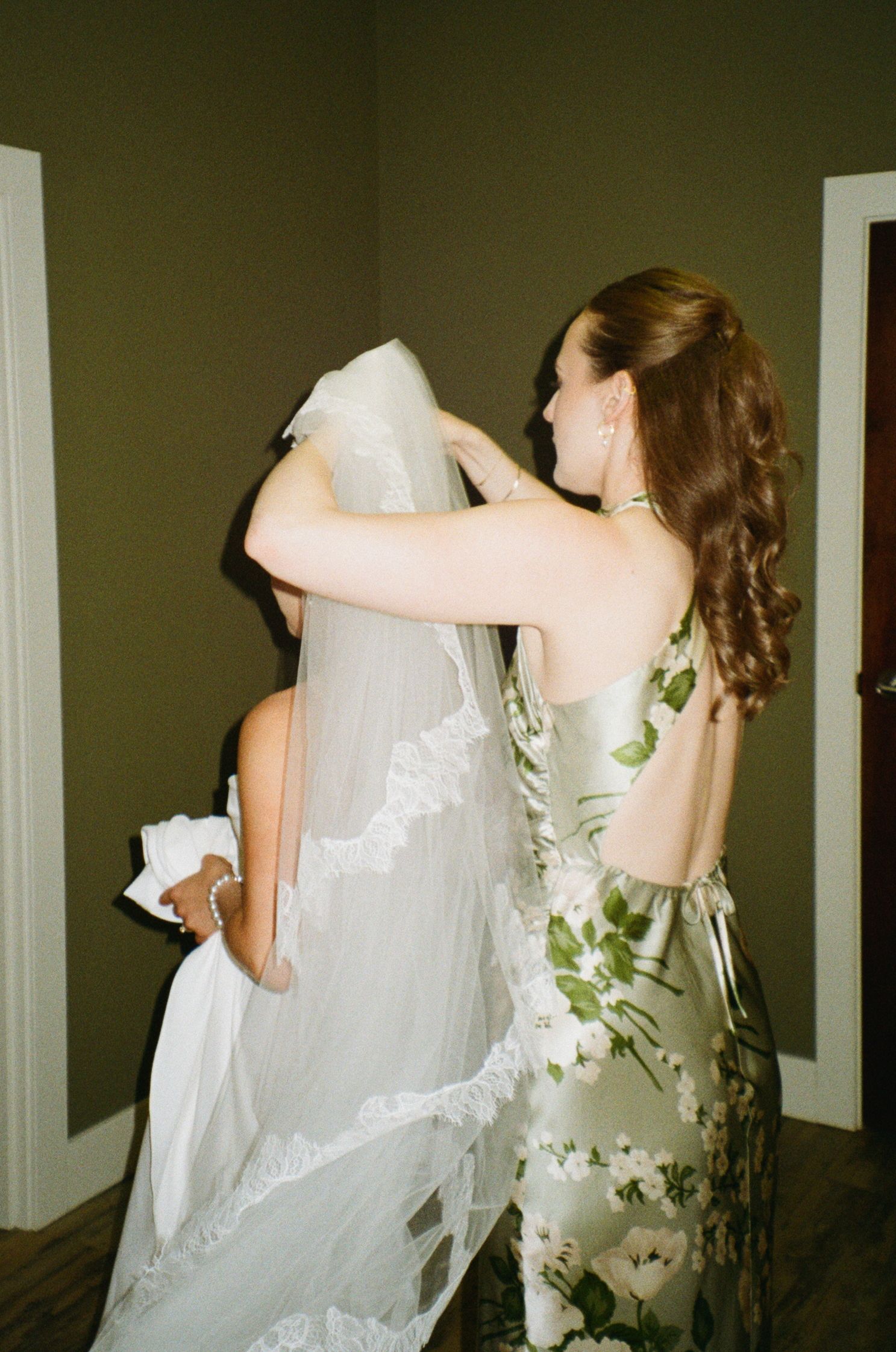 Flowing white wedding dress with delicate lace details captured in an artistic side view sequence.