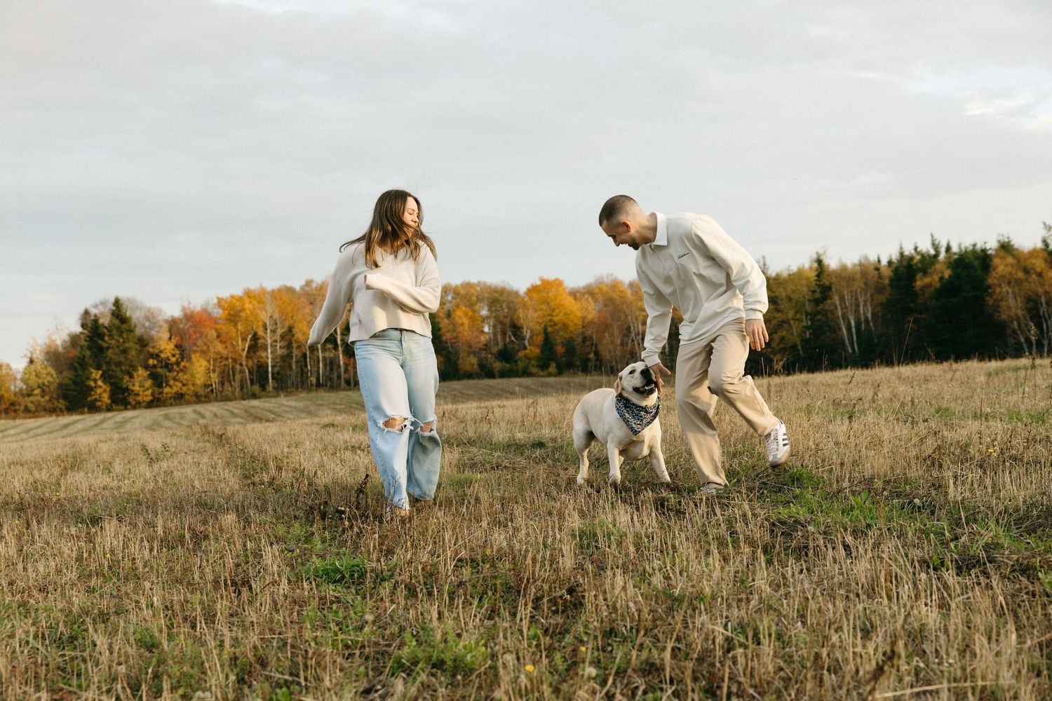People running playfully through a golden autumn field at sunset.