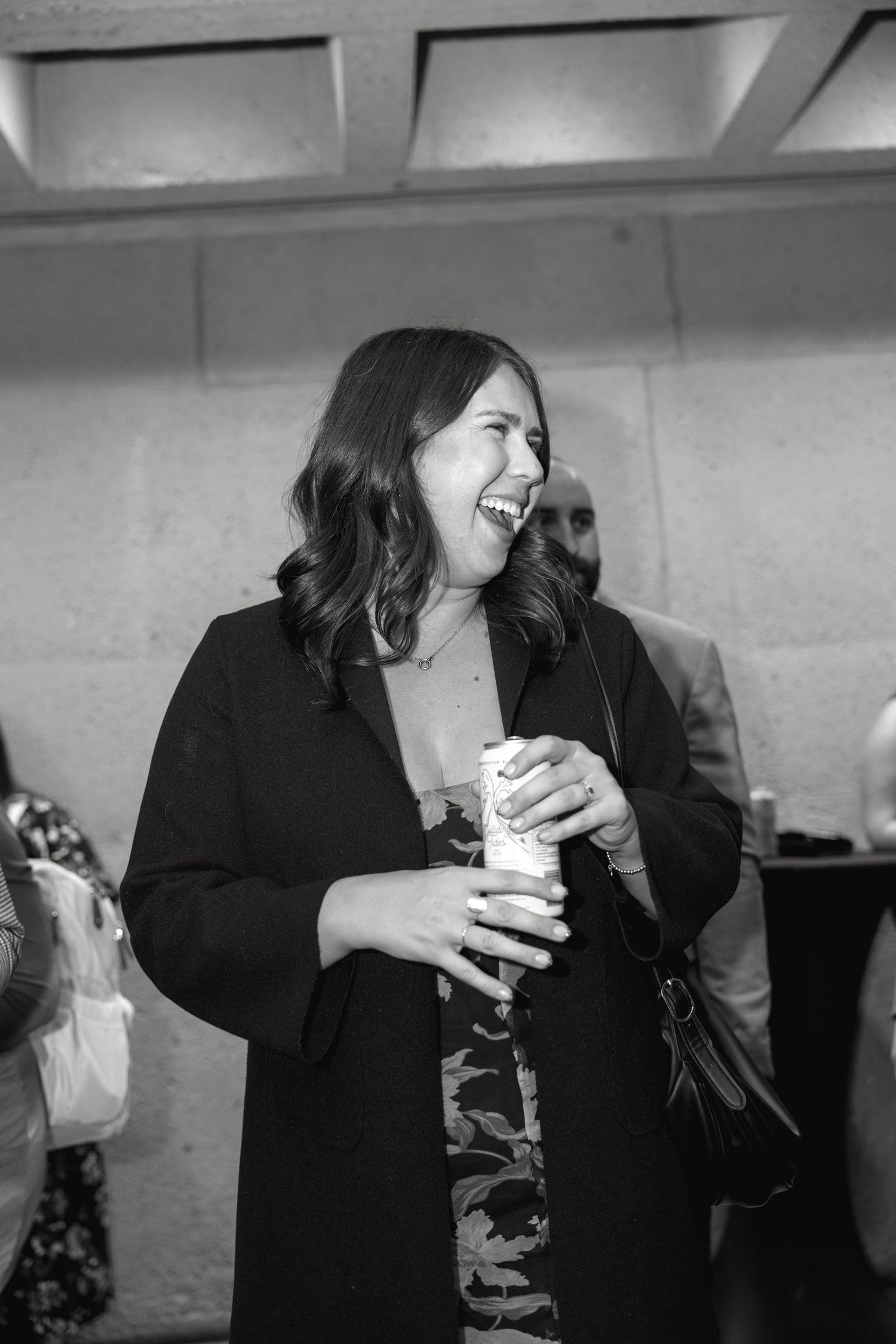Guests in formal attire enjoying drinks and conversation at a social gathering.