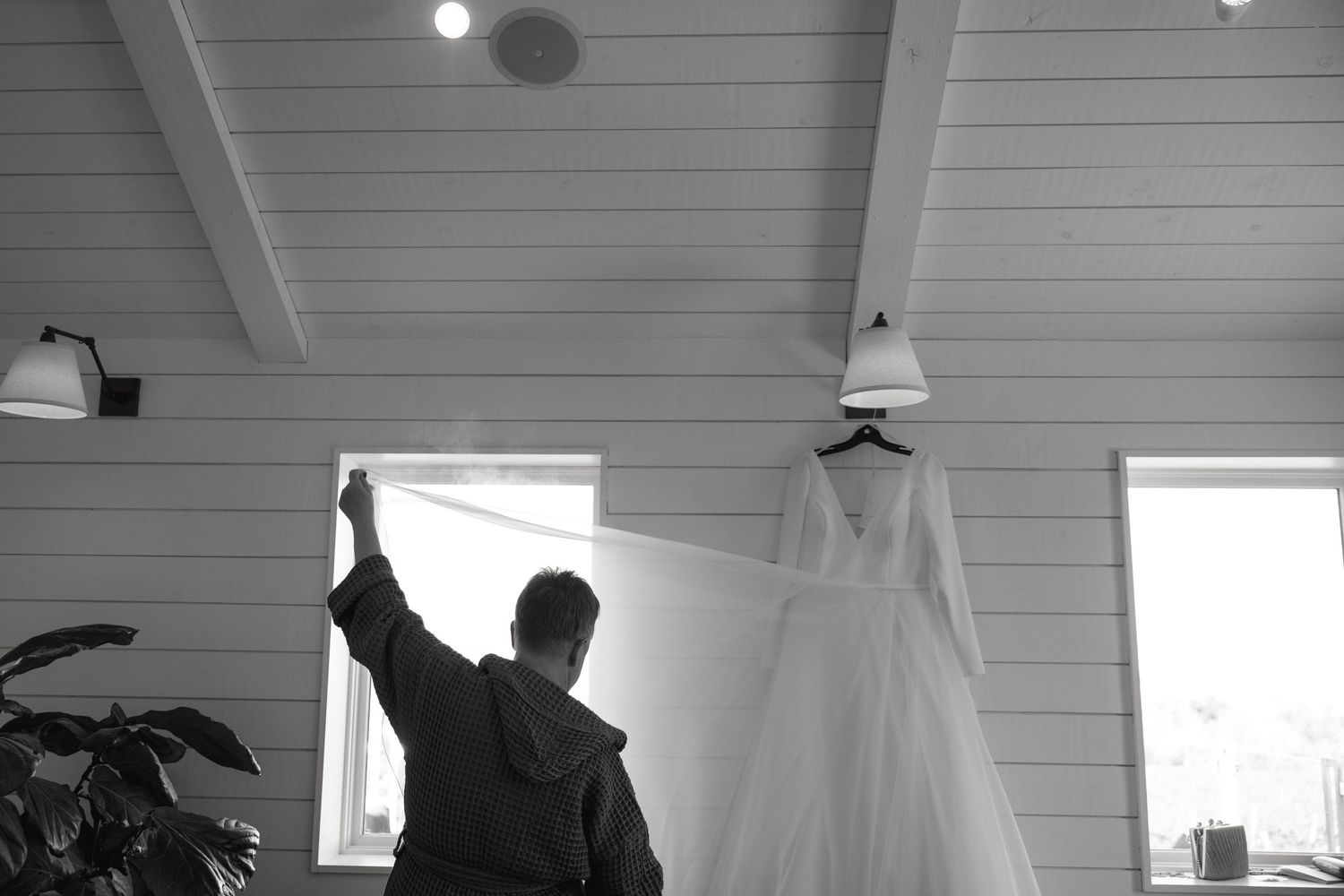 Interior view of a modern white room with vaulted ceiling and natural light streaming in.