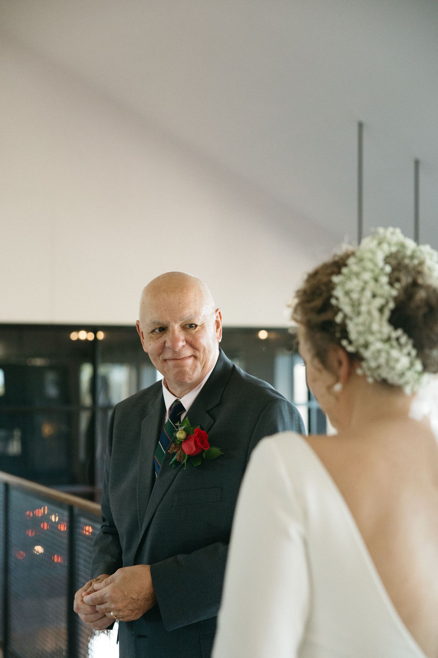 Wedding moment captured in an indoor setting with dramatic lighting.