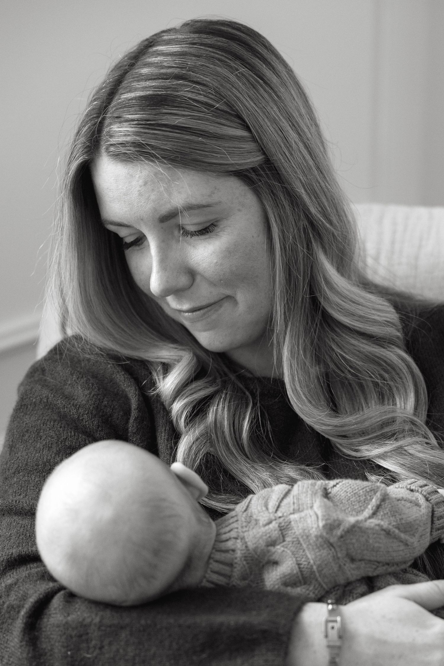 A tender moment showing someone cradling and gazing lovingly at a newborn baby.