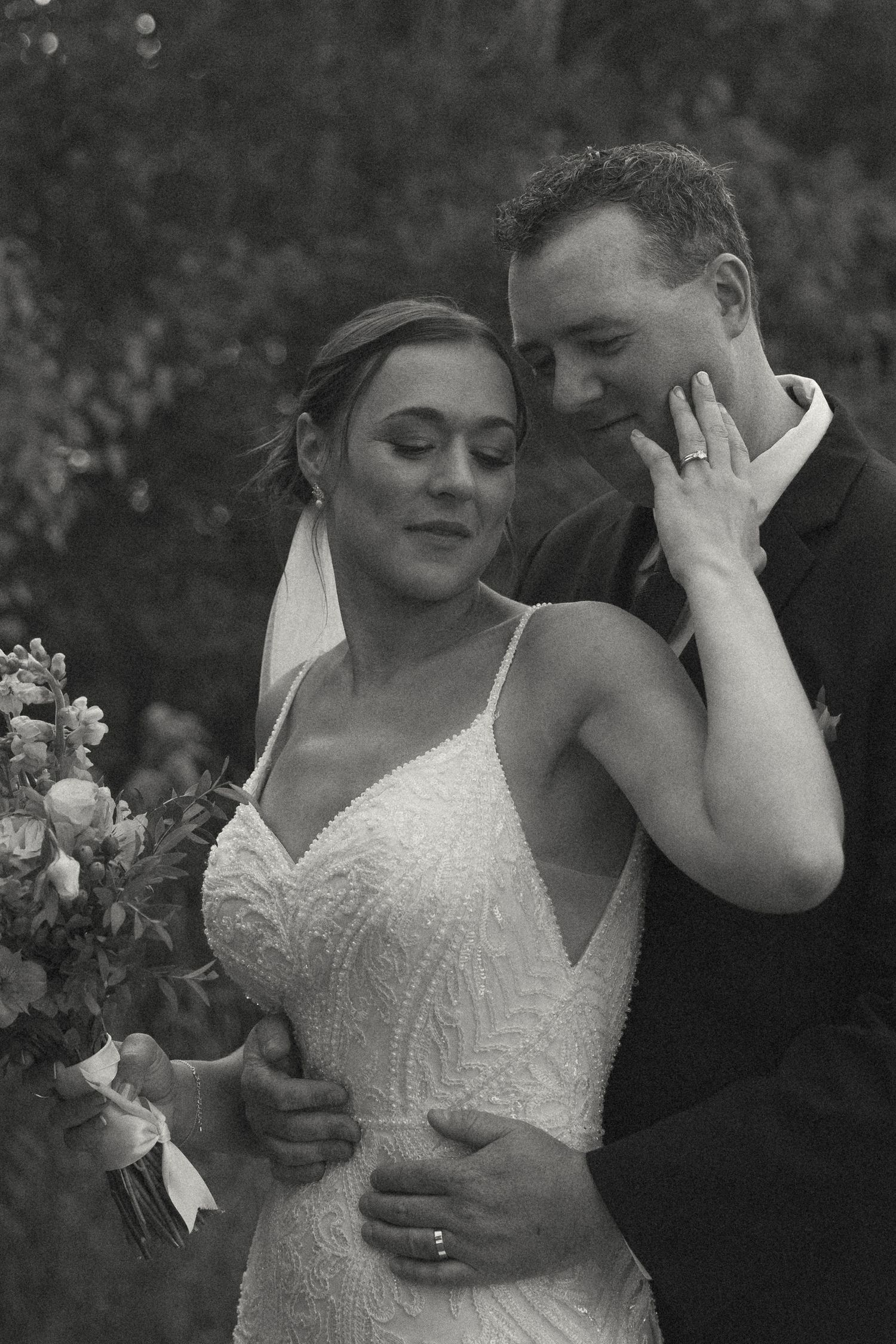 Intimate black and white wedding portraits captured in natural outdoor setting.