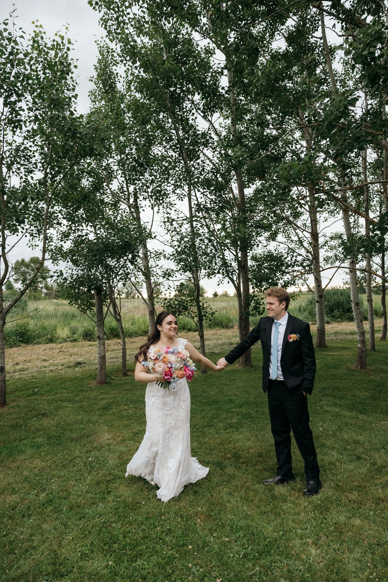 A playful wedding photoshoot sequence with the couple dancing and twirling in a grove.