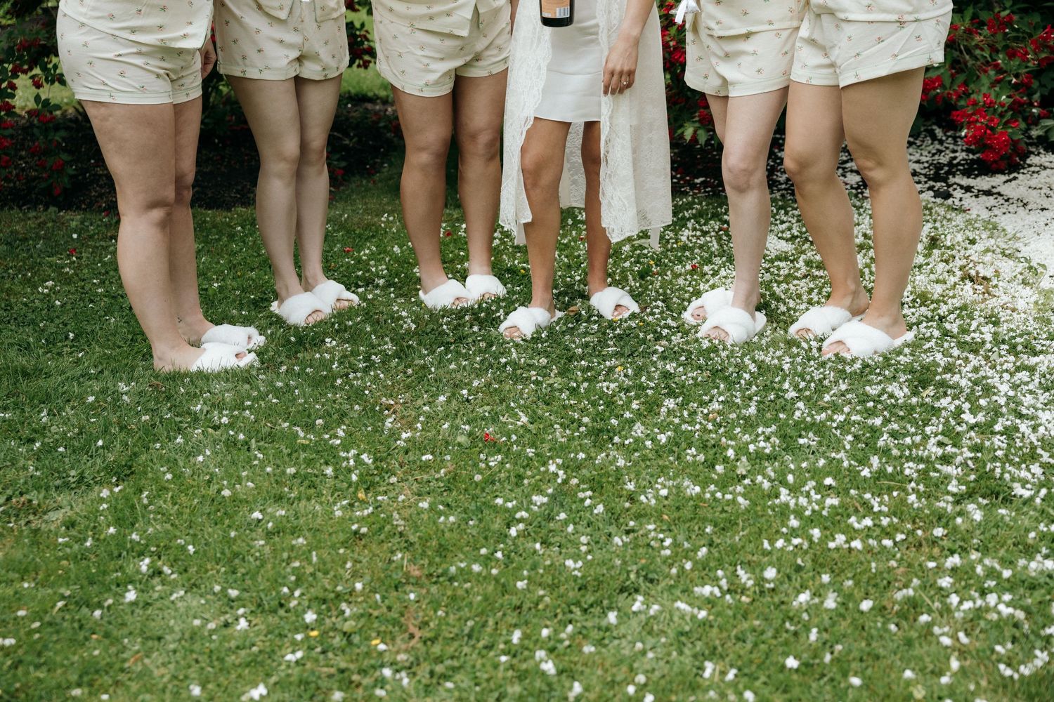 Group wearing matching khaki shorts and white shoes standing on grass covered in flower petals.