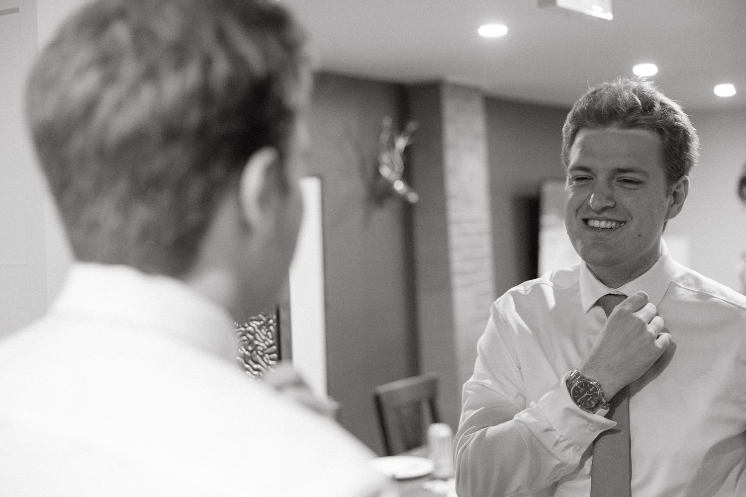 Black and white candid photography of wedding preparation moments.