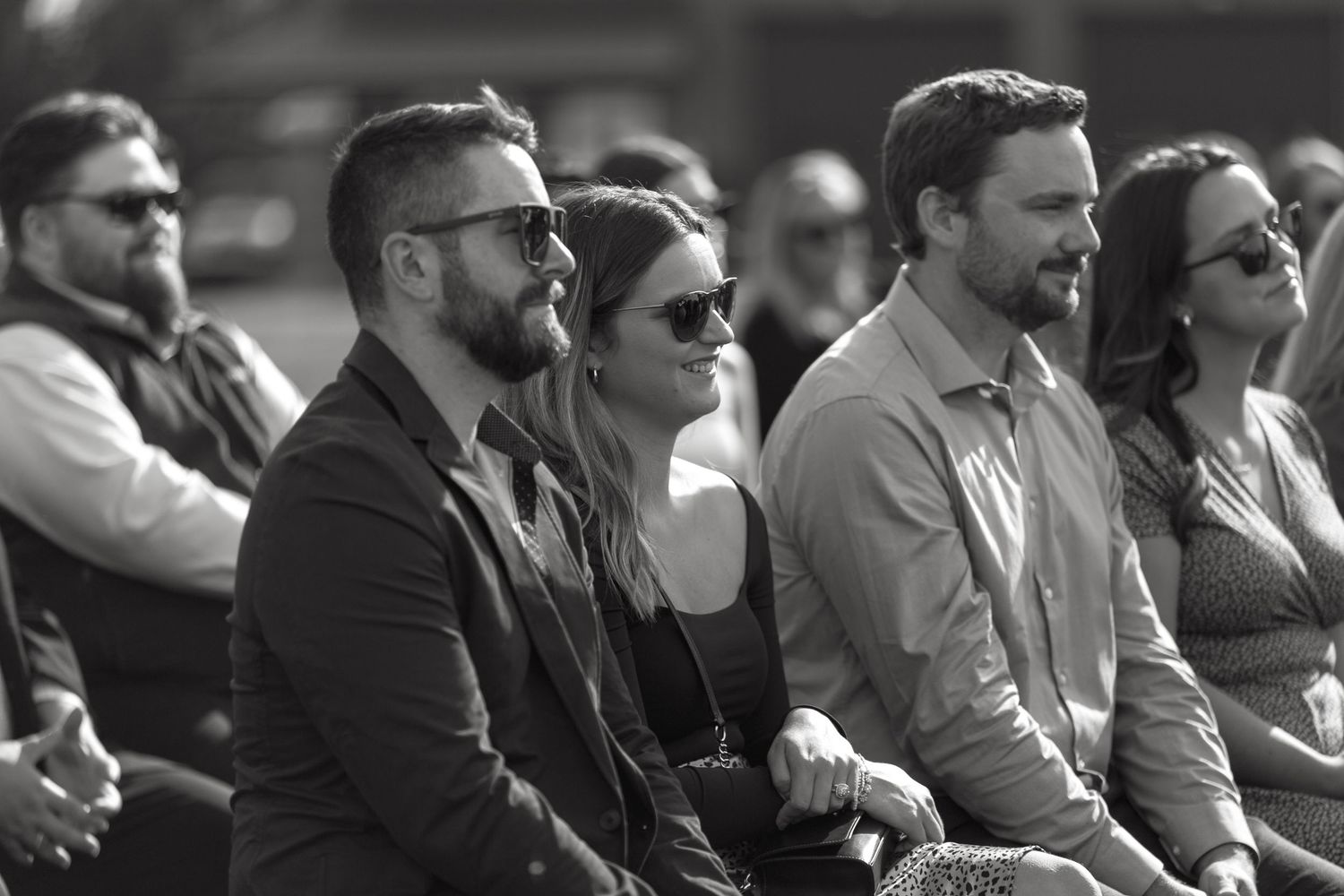 Black and white photo of wedding guests seated in rows during ceremony.