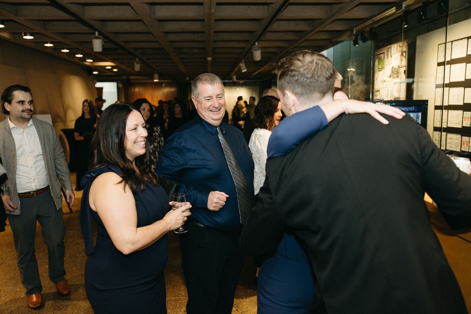 Party guests dancing and mingling at an indoor event venue.