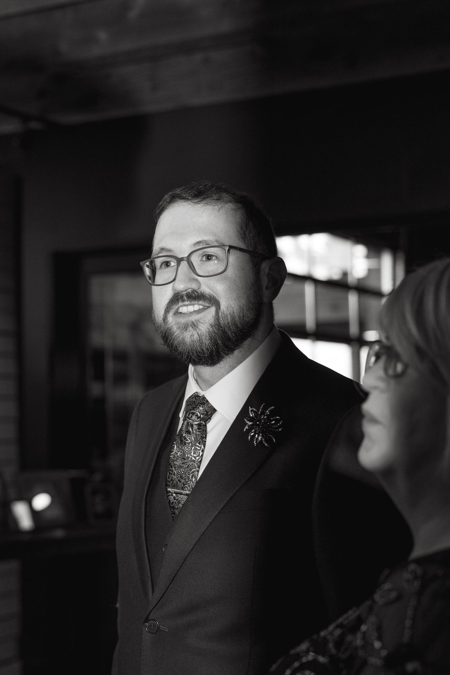 Black and white portrait of a guest in formal attire at an event.