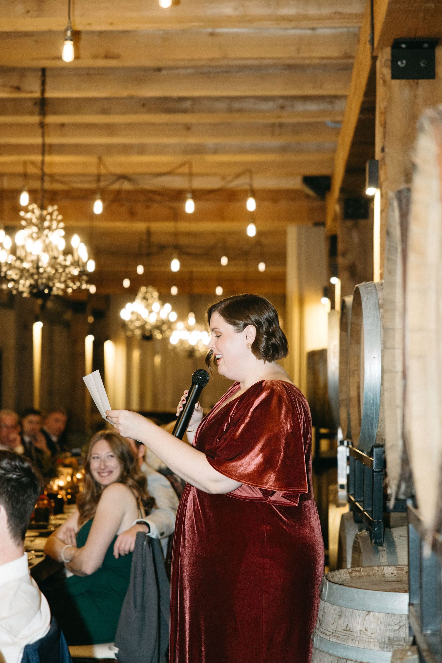 Wedding celebration in an industrial venue with exposed beams and hanging string lights.