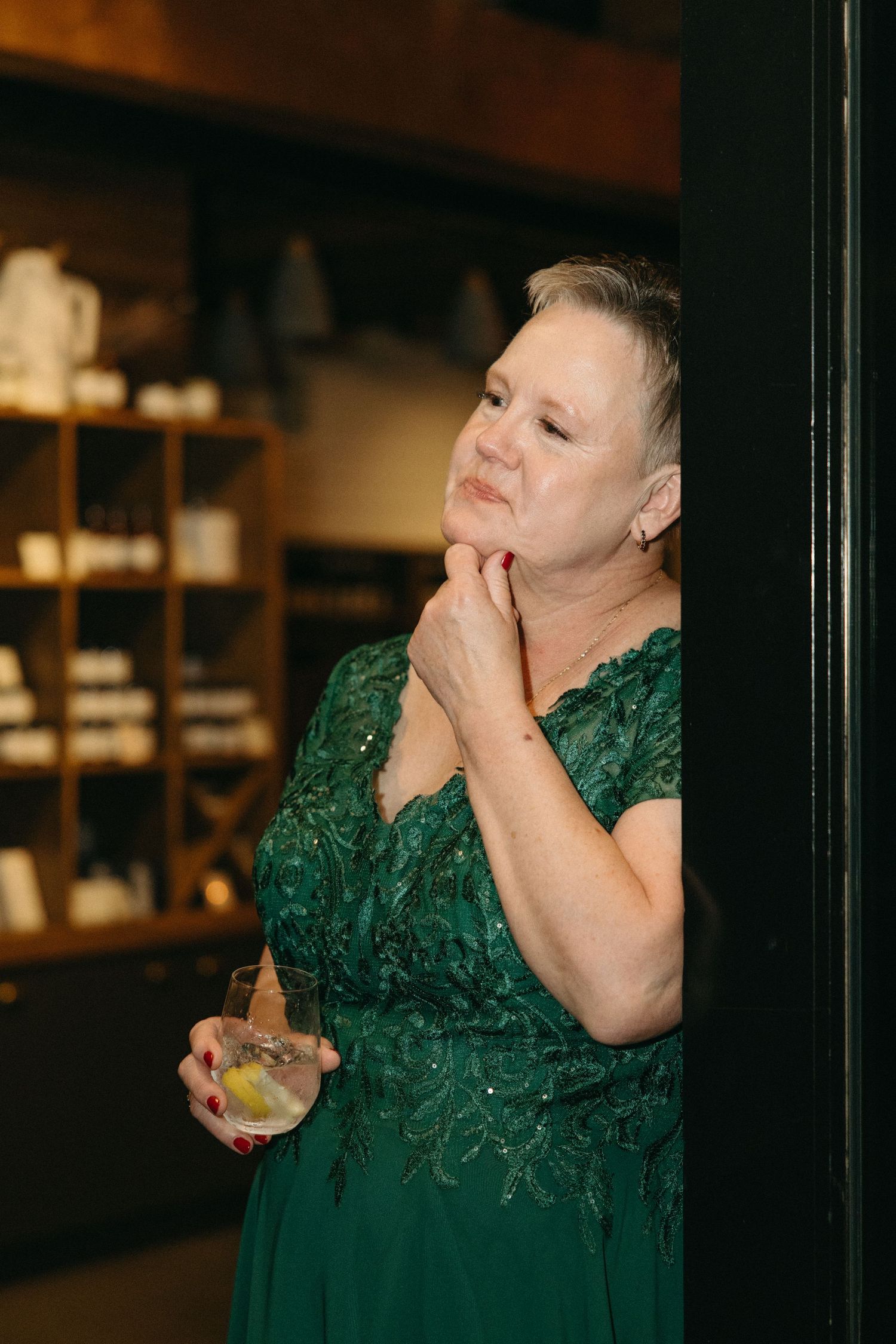 Person in an emerald green dress reacting emotionally at a formal event.