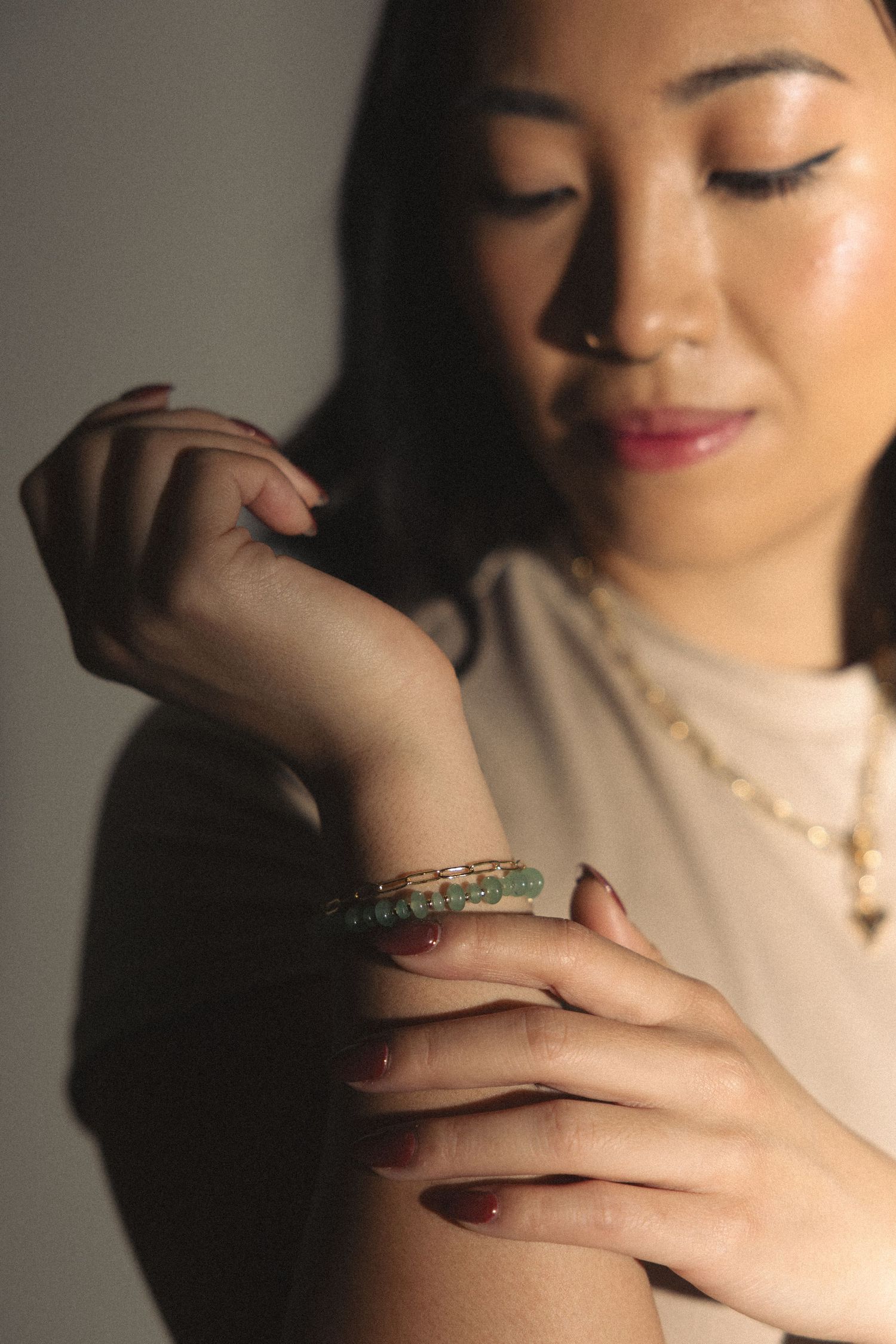 Artistic jewelry photography showing bracelet and hand details in soft lighting.
