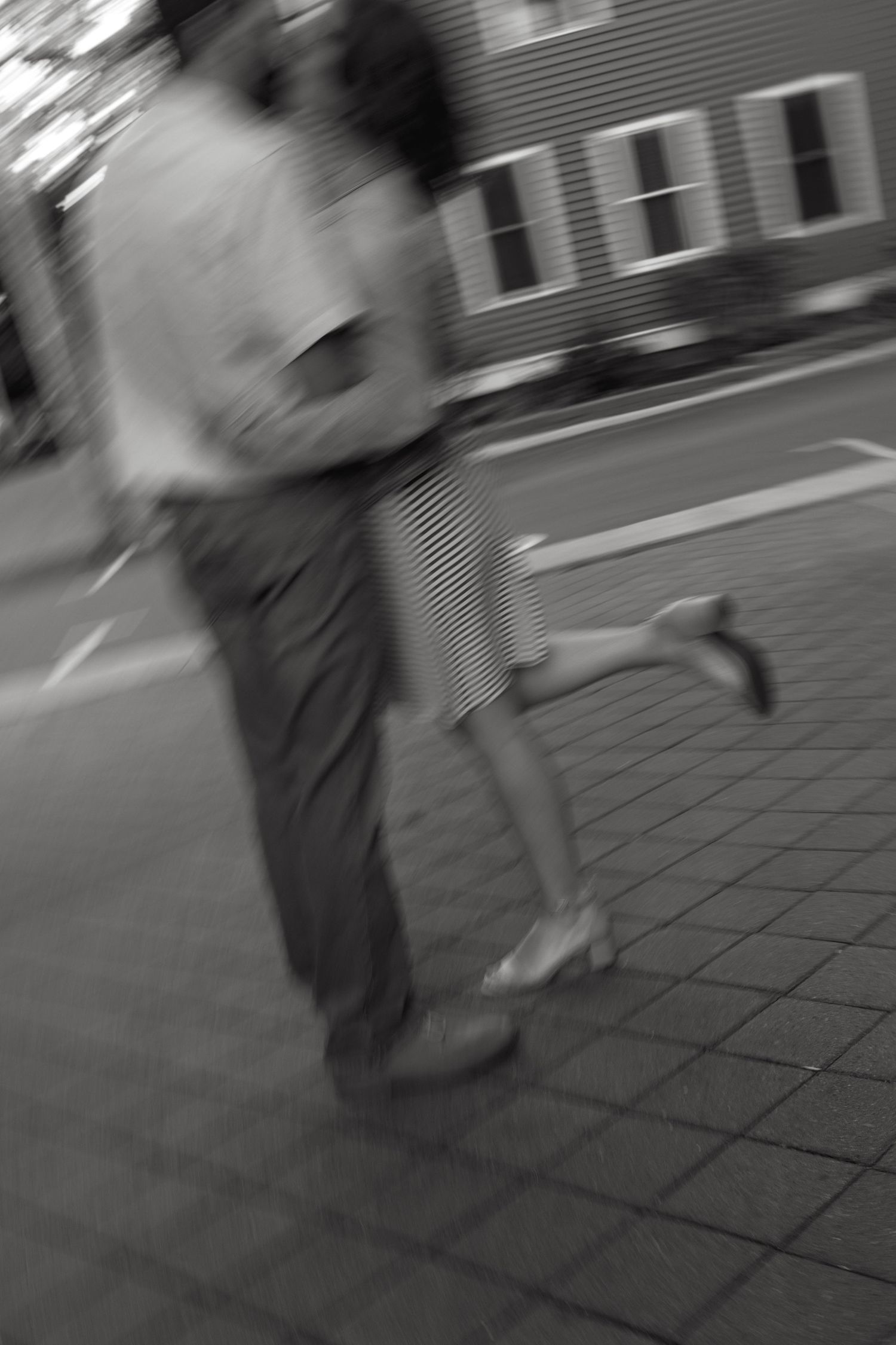 Blurred motion black and white image of people on a city sidewalk.
