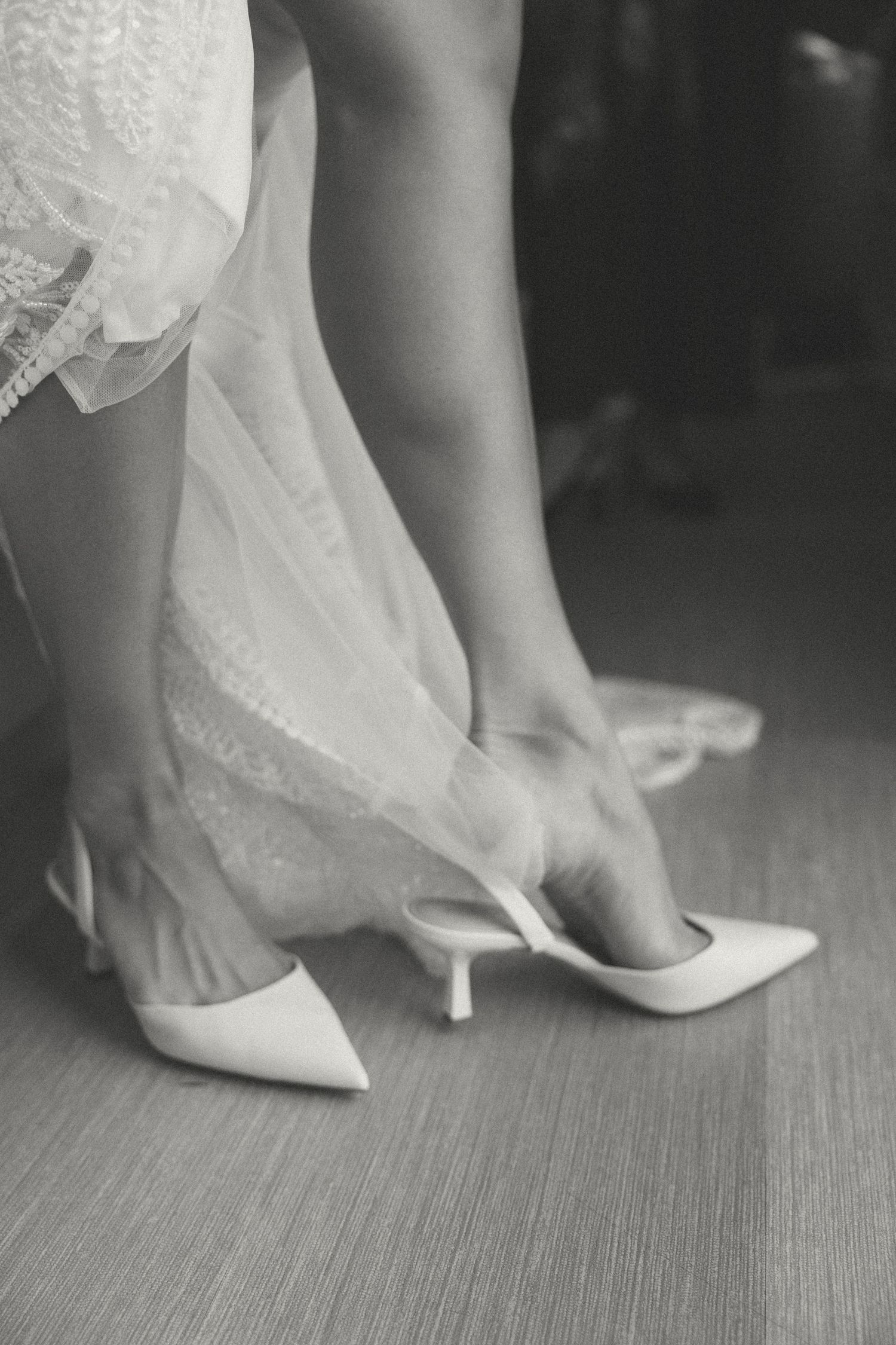 Black and white detail shots of bridal shoes being put on before the ceremony.