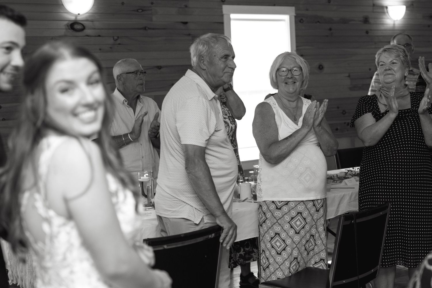 Black and white panorama of wedding guests dancing and celebrating on the dance floor.