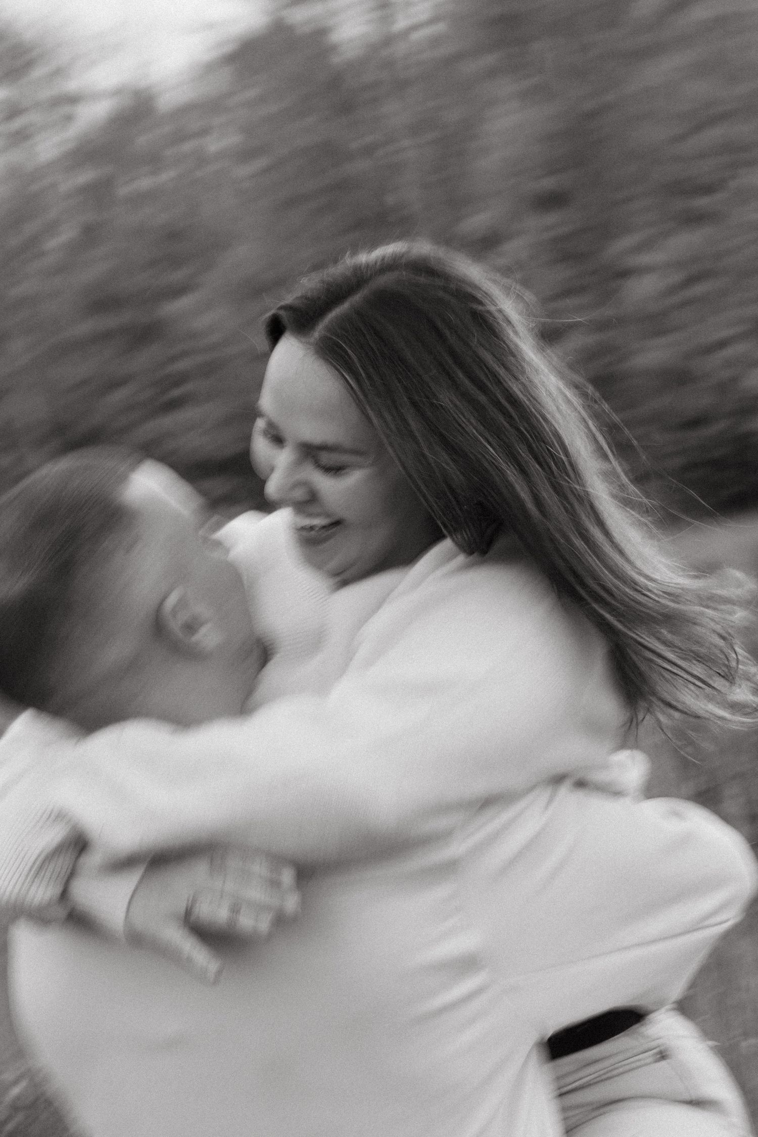 Motion blur photograph of two people dancing and spinning in nature.