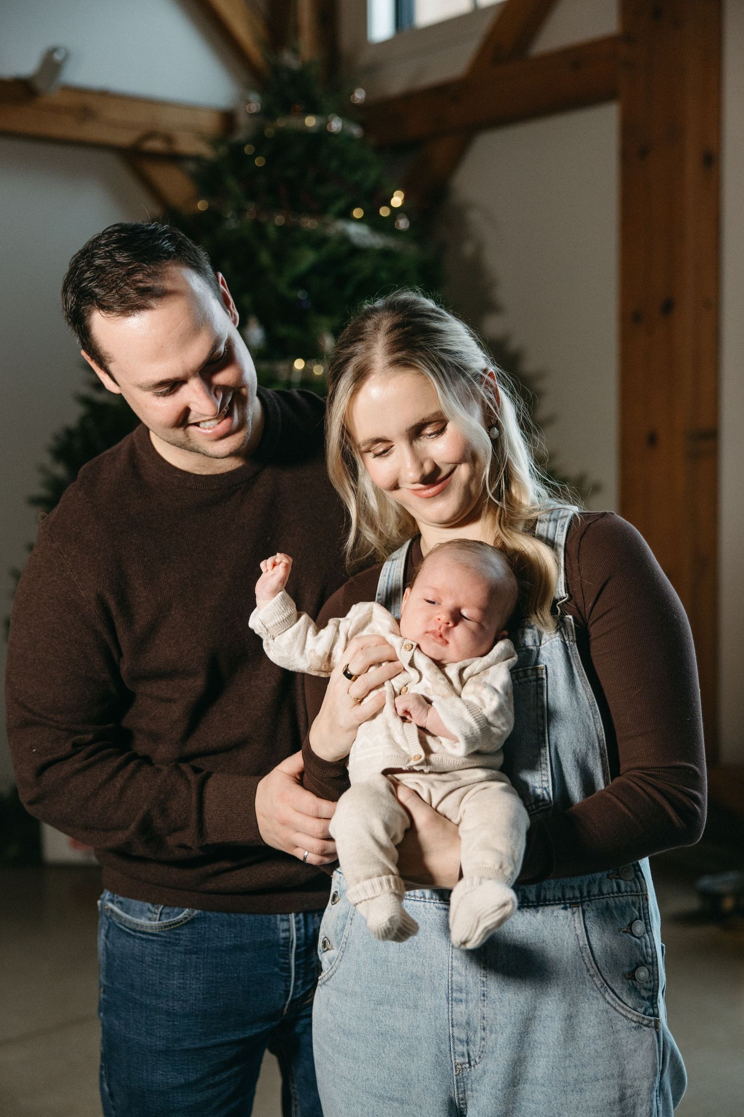 Intimate family portraits showing joyful interactions with a baby during holiday season.