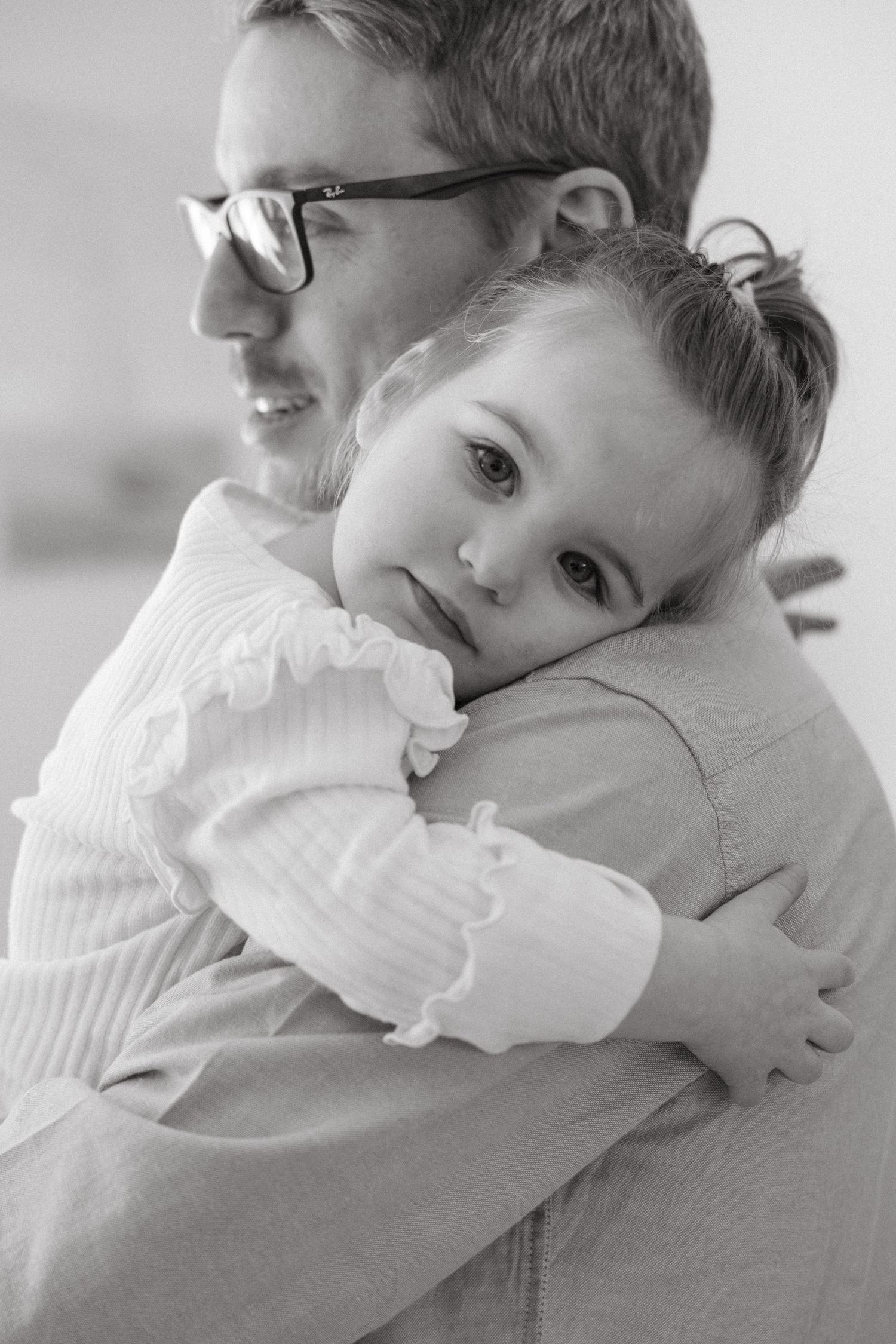 A touching black and white moment shows a child hugging in a white sweater.