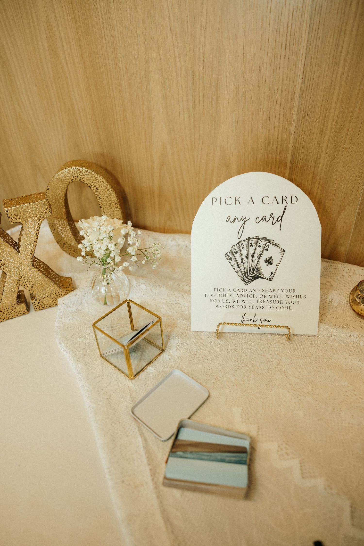 Wedding reception details showing card box and signage with gold geometric decorations.