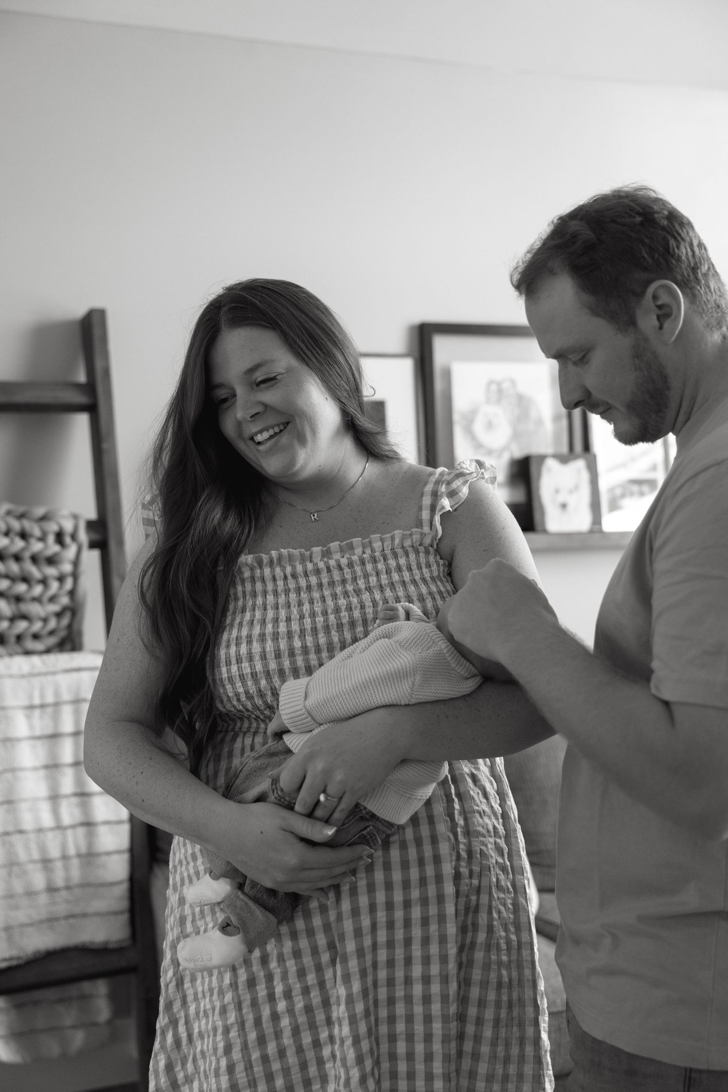 A couple shares tender moments with their newborn baby in a series of intimate black and white photographs.