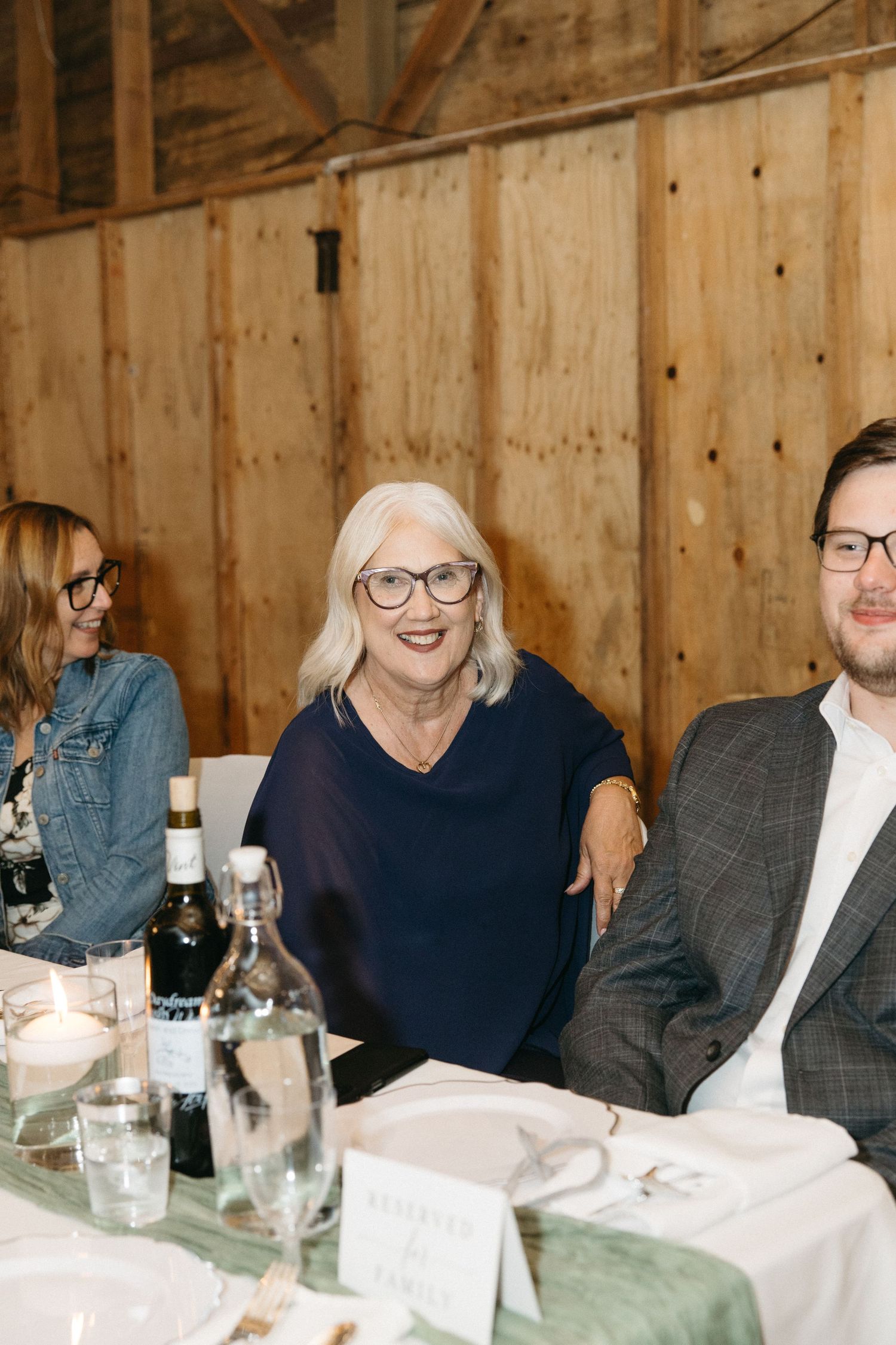 Guests enjoy dinner and conversation at tables during an indoor wedding reception.