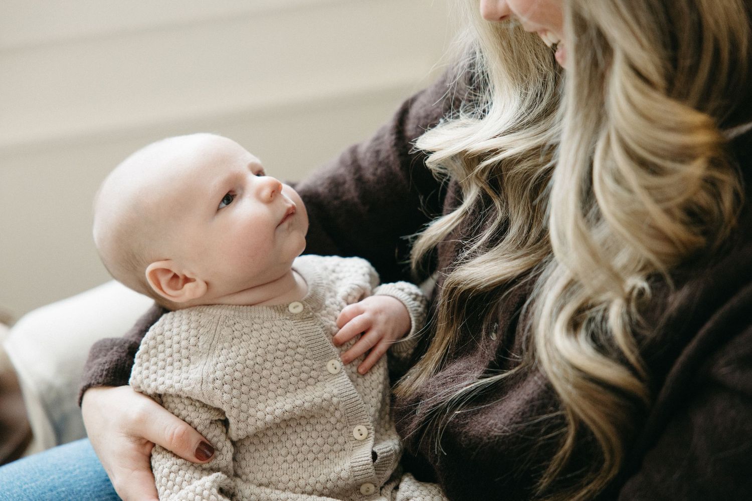 A tender moment captured between parent and baby on a comfortable sofa.