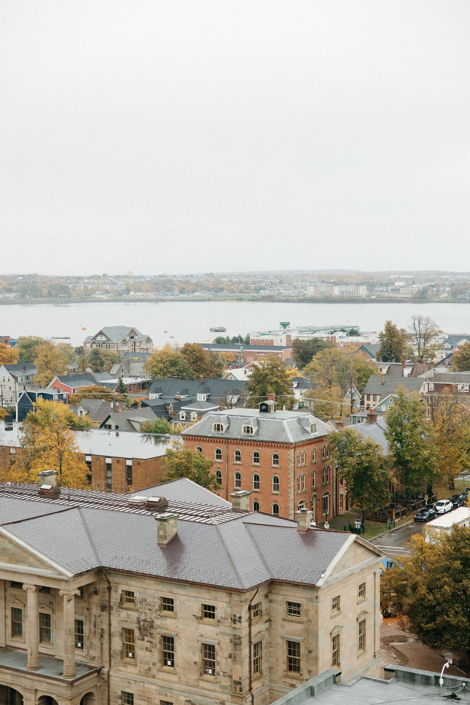 Panoramic cityscape view showing historic buildings and autumn trees.