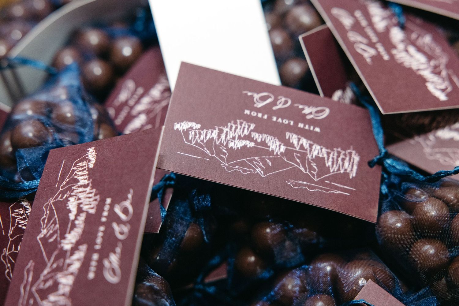 Dark burgundy wedding invitations or place cards with elegant calligraphy.