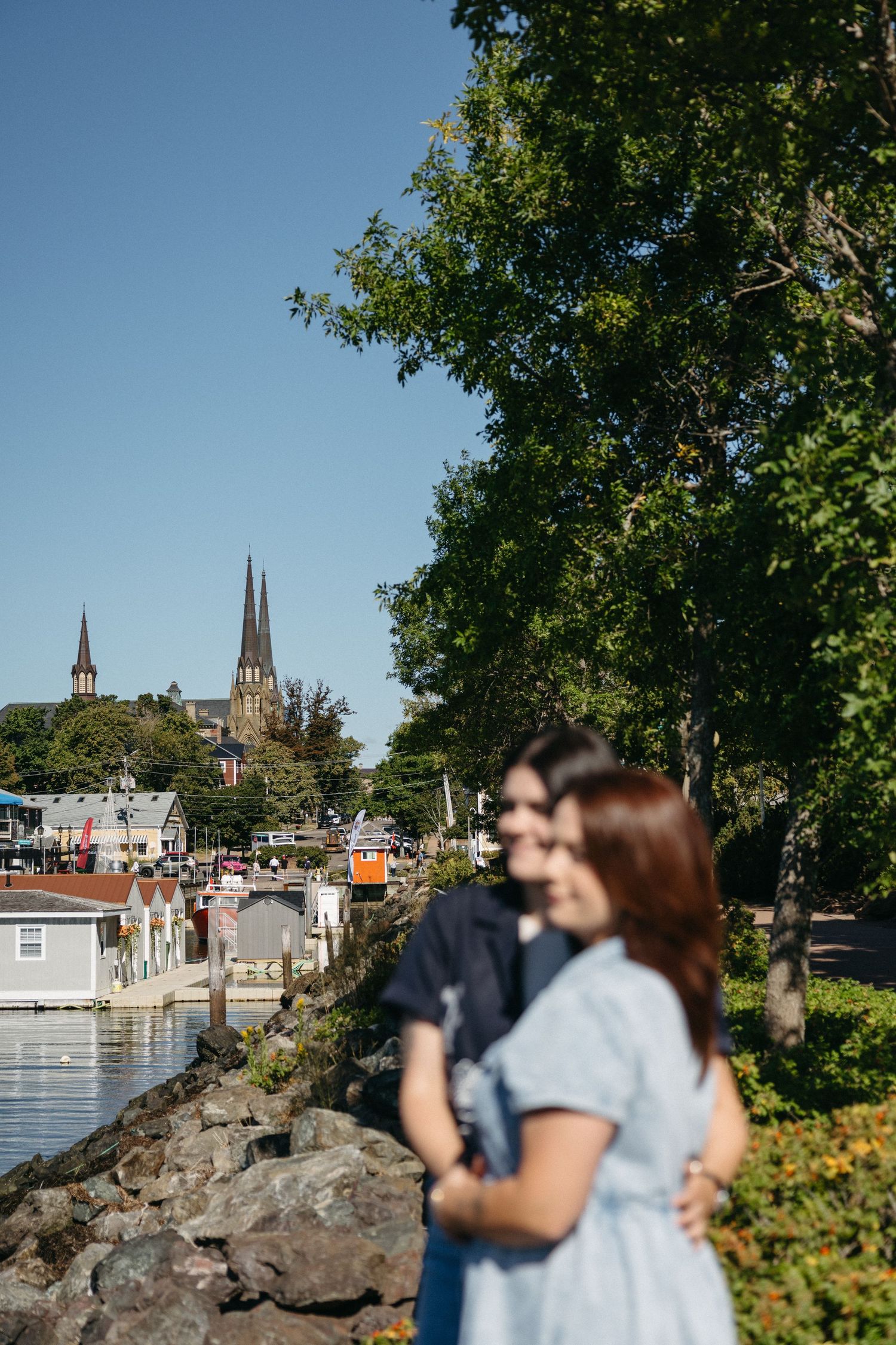 Scenic waterfront view of a European town with Gothic church spires visible in the distance.