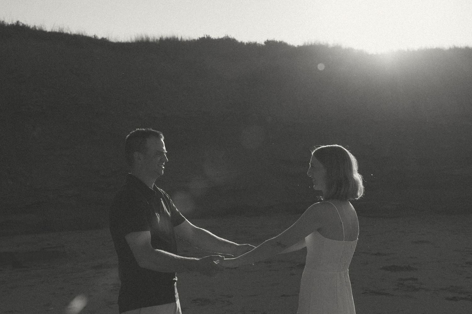 Silhouettes of two people walking together against a dramatic sunset sky.
