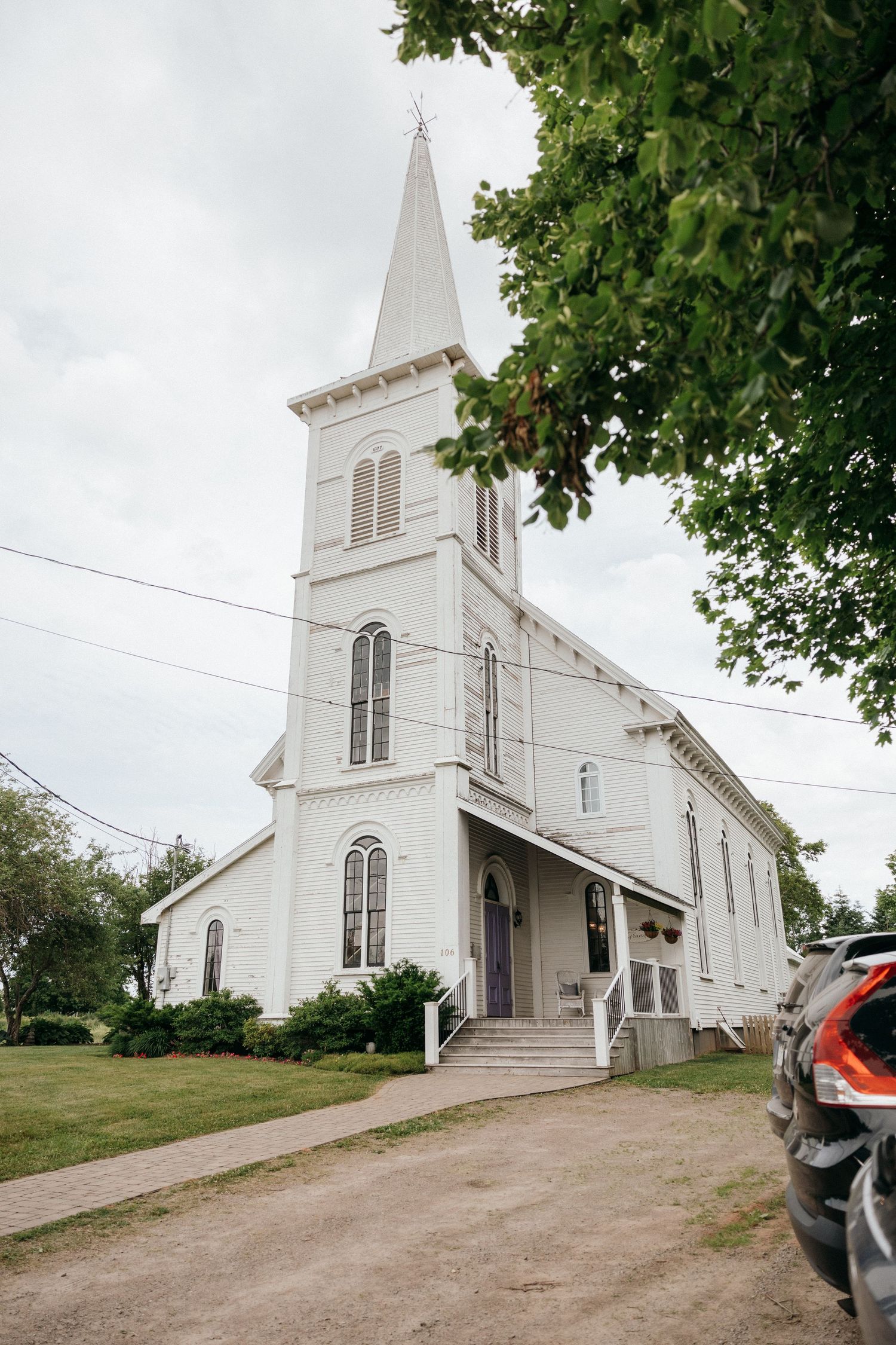 A classic white church with tall steeple photographed from different angles on an overcast day.