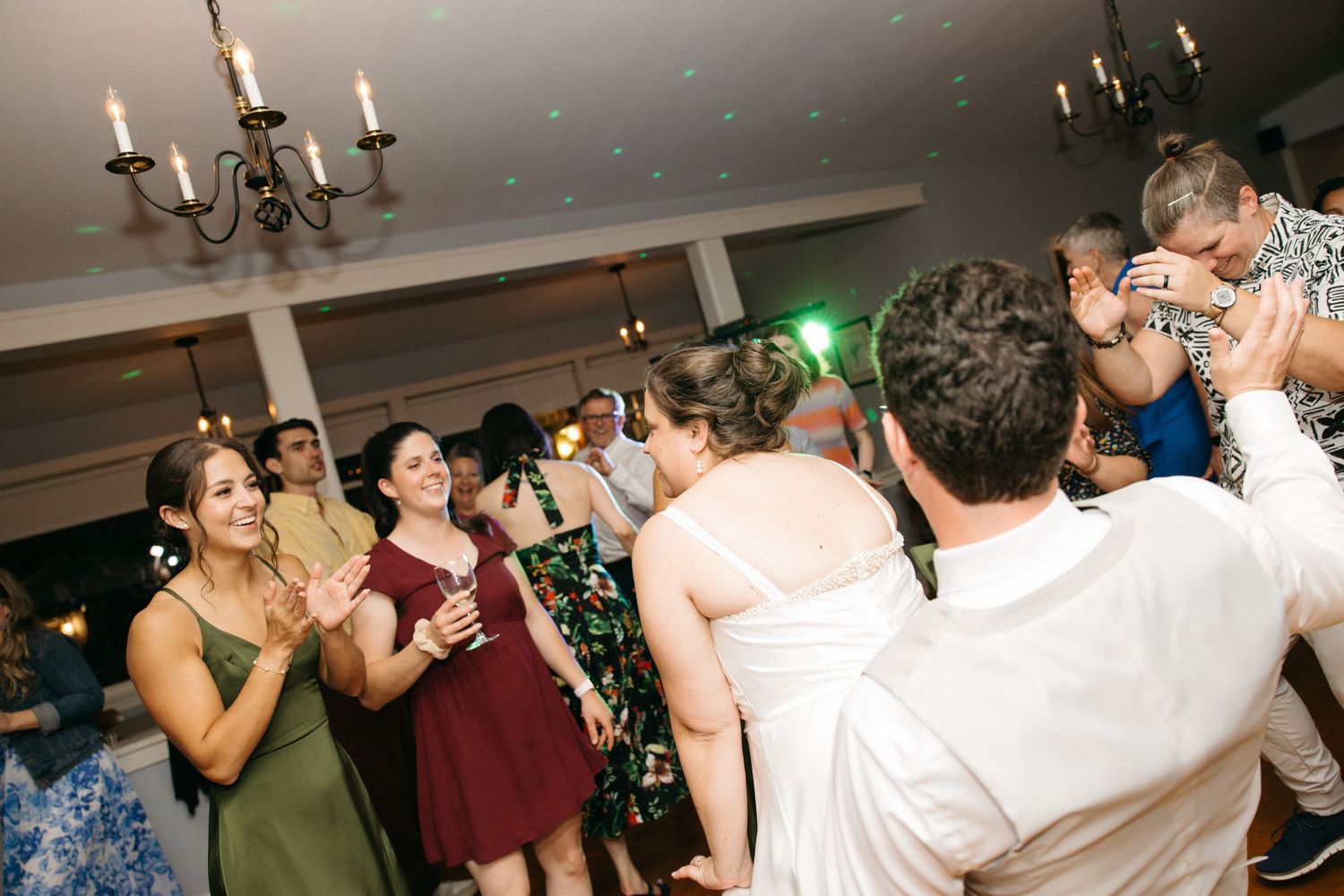 Joyful wedding guests dance and celebrate on the dance floor during a lively wedding reception party.
