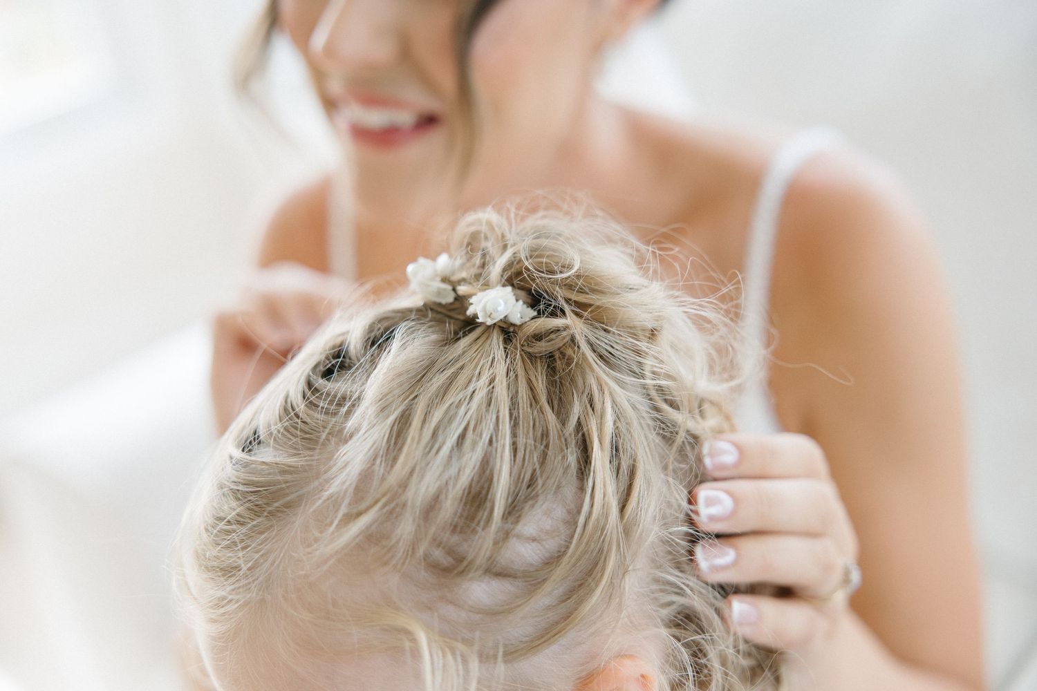 Close up of bridal hair styling with floral accessories.