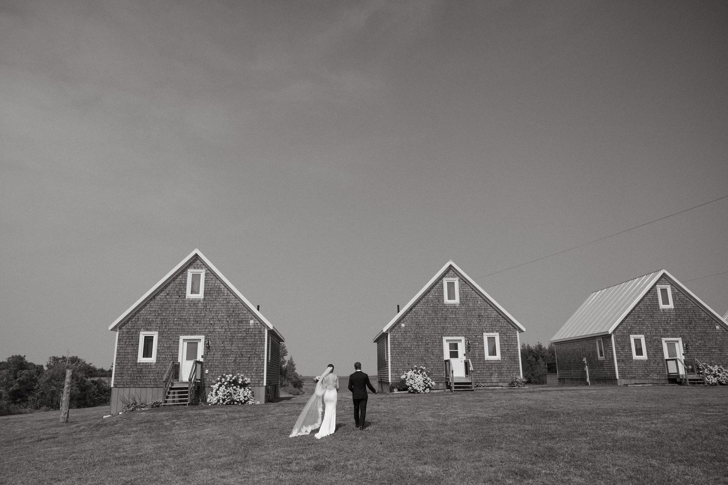 Row of red-roofed cottages on a hilltop against cloudy sky.