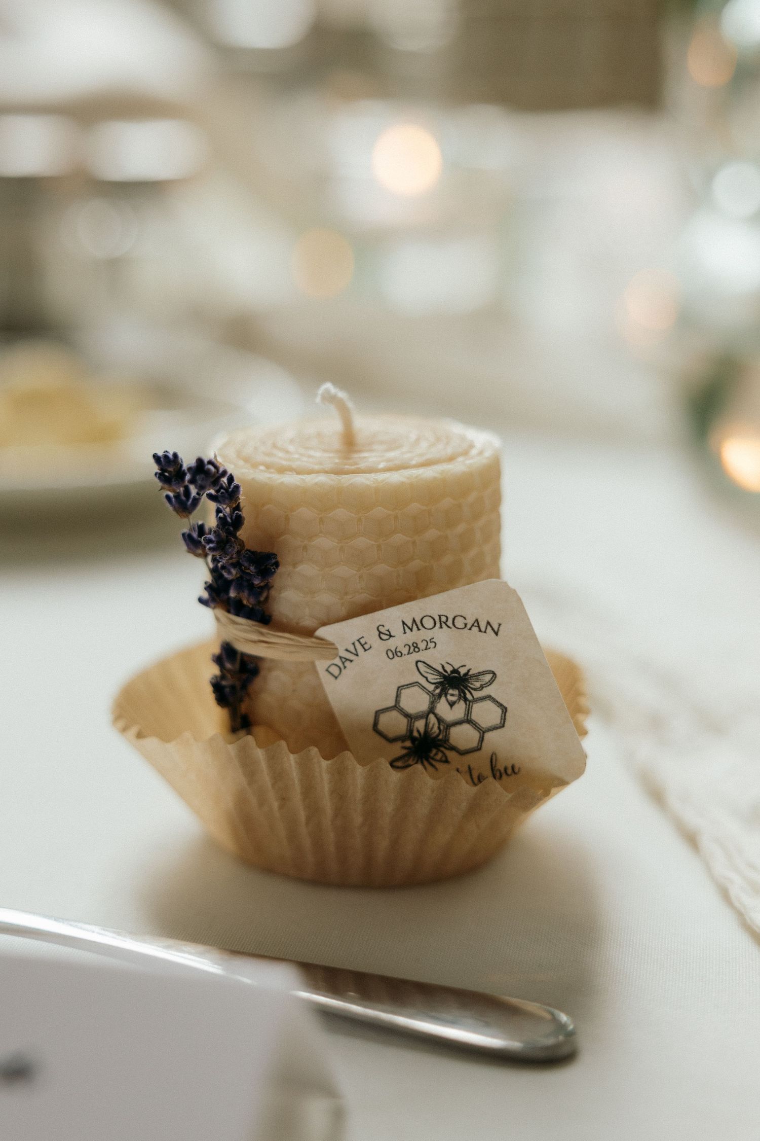 Wedding favor honey jars with custom bee logo labels and decorative details.