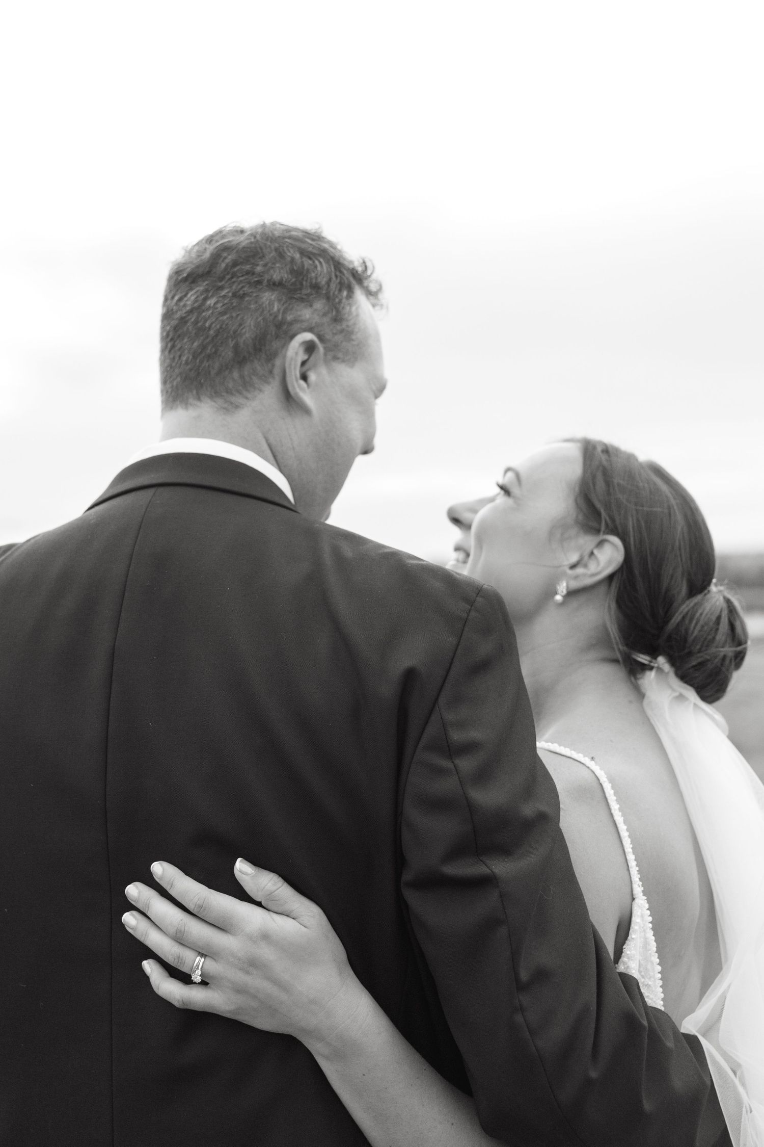Black and white portrait of newlyweds sharing a joyful moment together.