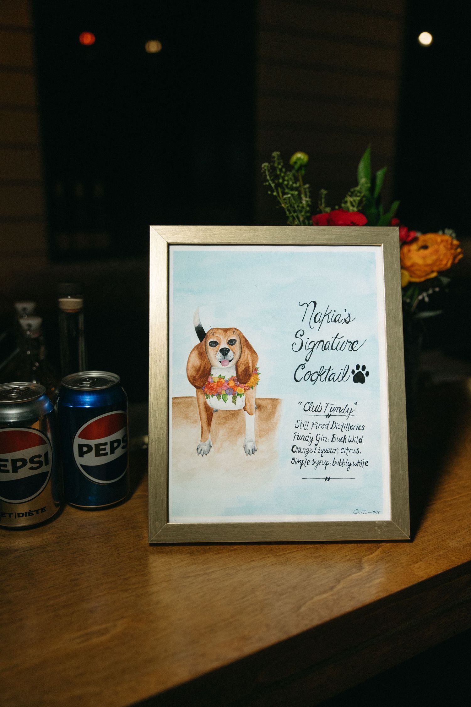 Table display featuring framed artwork of a dog and decorative signage.
