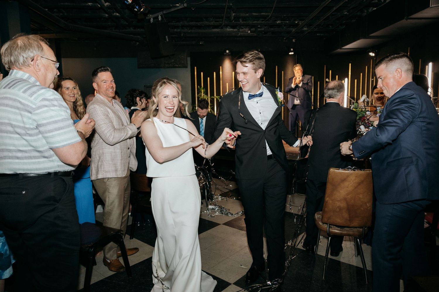Wedding celebration with guests dancing and enjoying themselves in an industrial venue.
