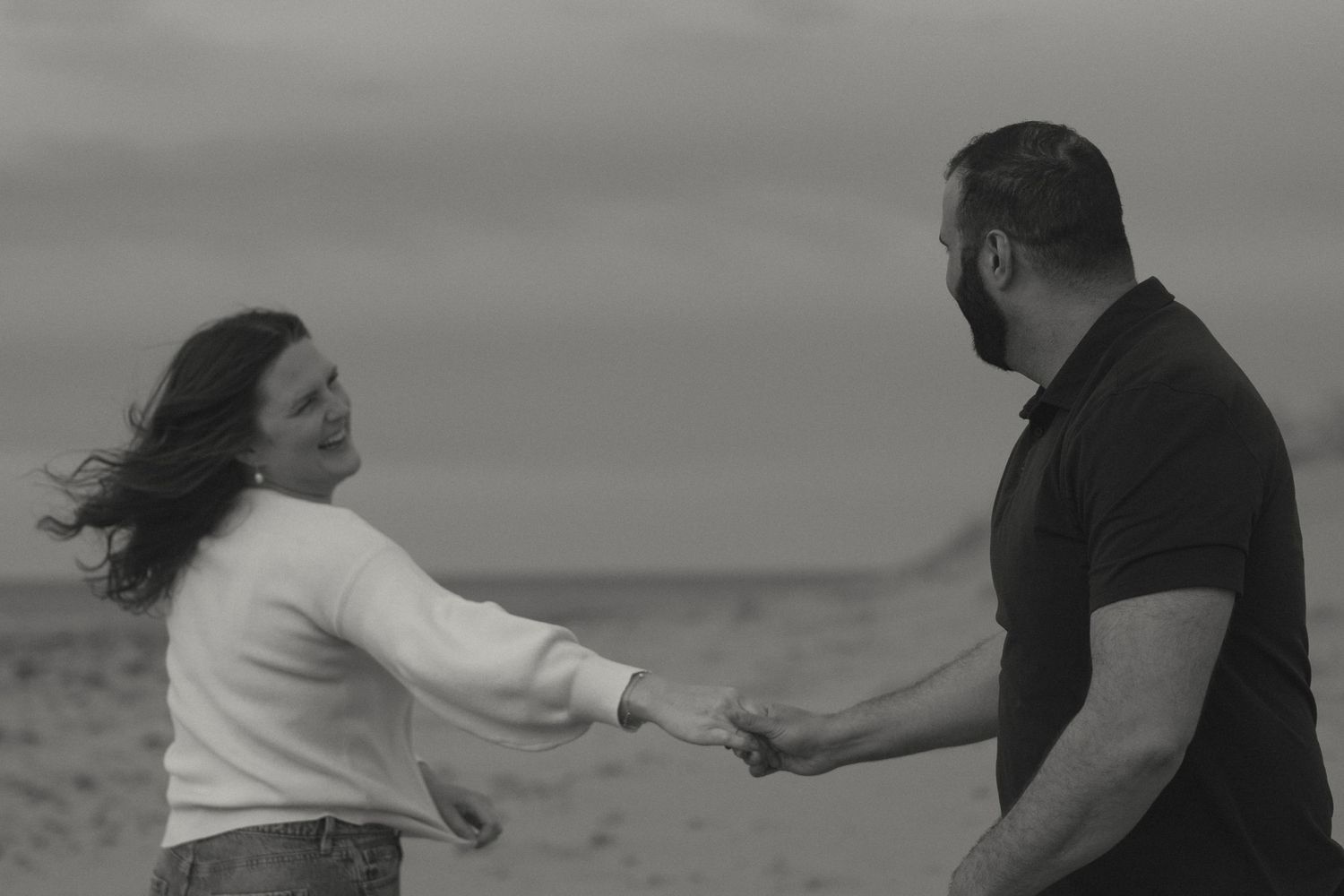 A series of black and white photographs capturing a couple dancing and embracing on a beach.