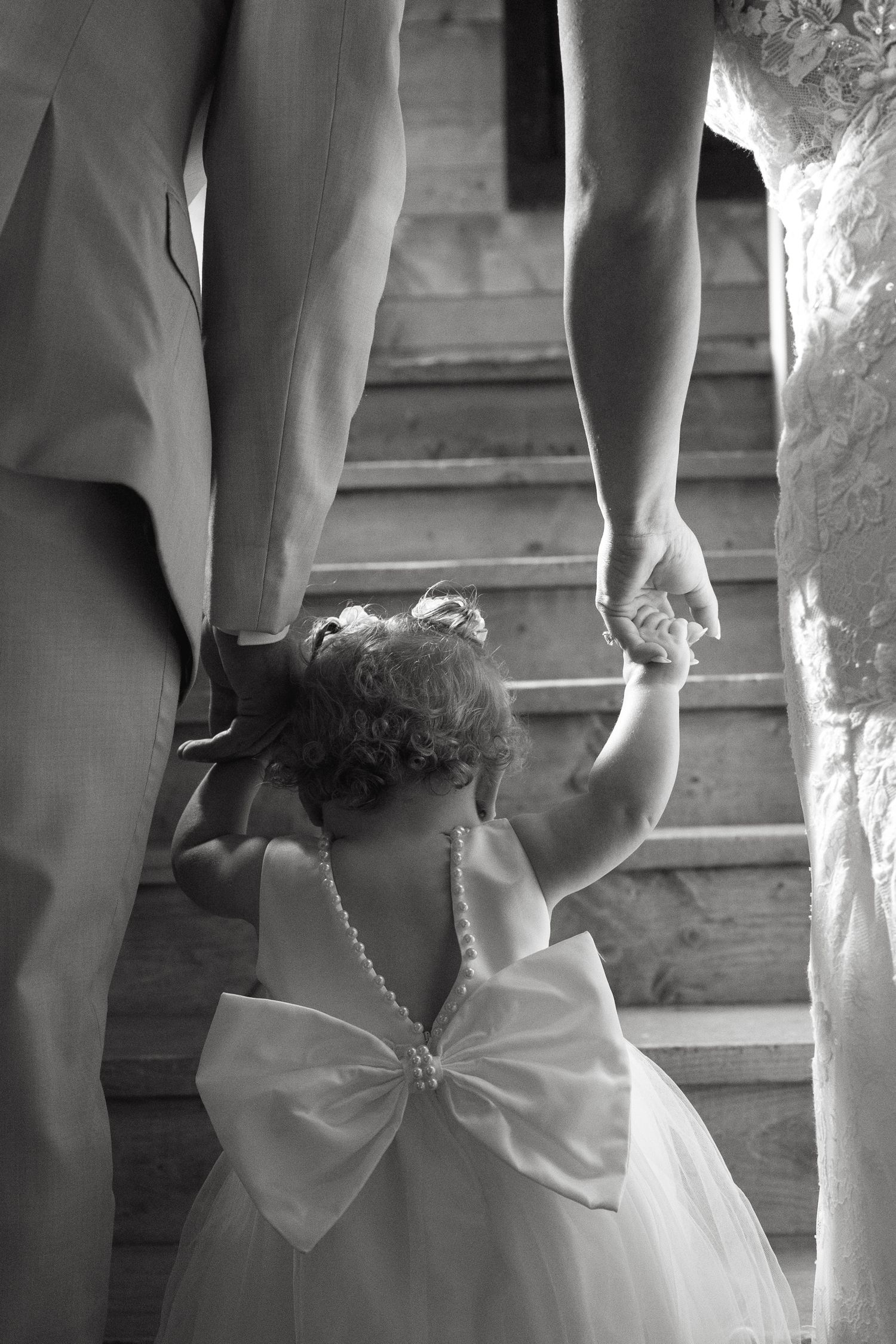 Close-up details of wedding dress backs with bows and lace in black and white.