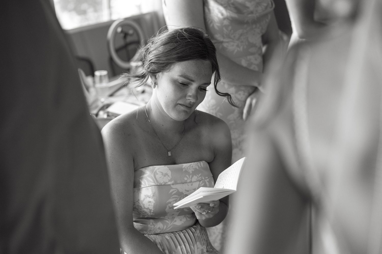A candid moment captured in black and white as someone reads during a special occasion.