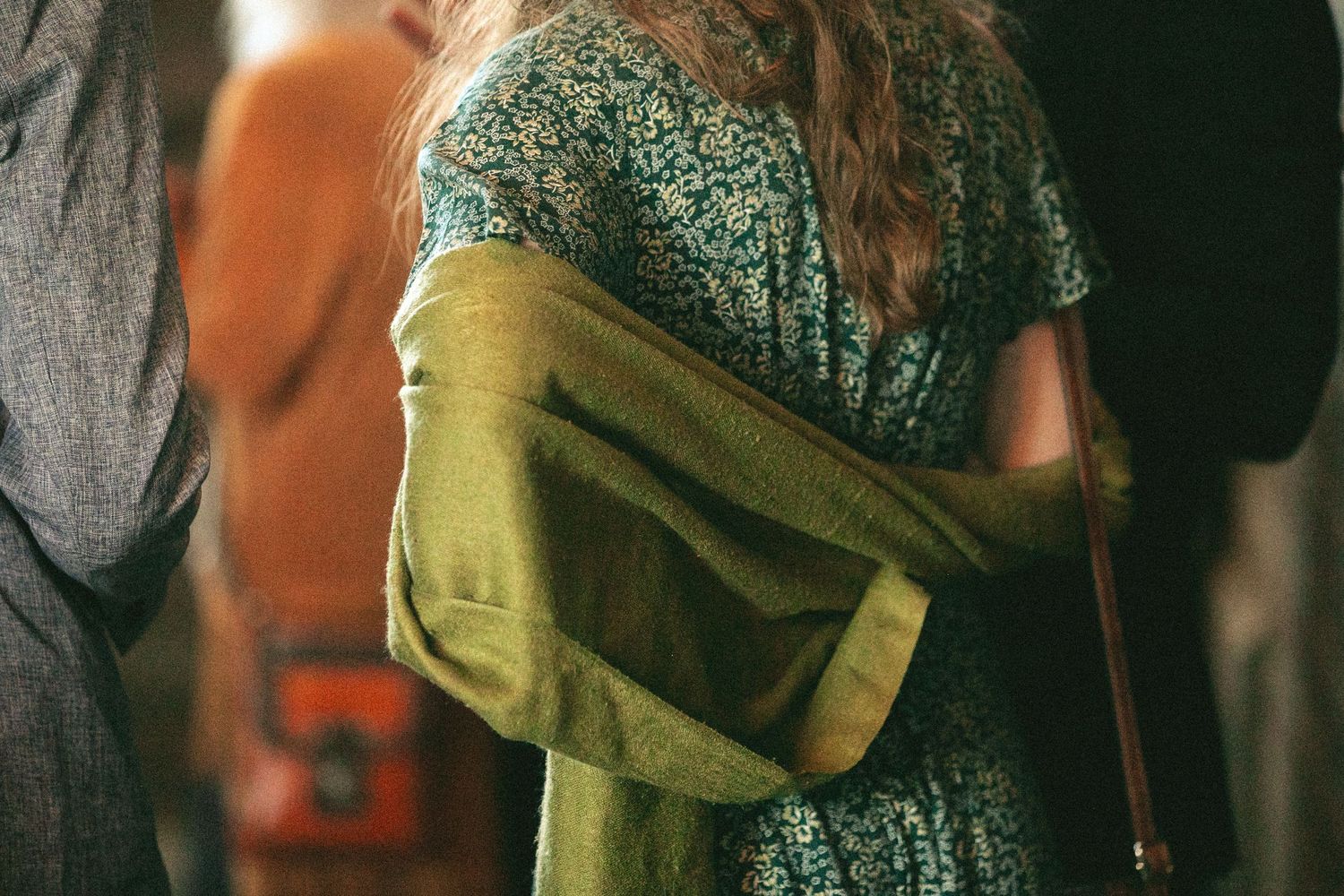 Close-up of a sparkly dress detail with olive green fabric draping.