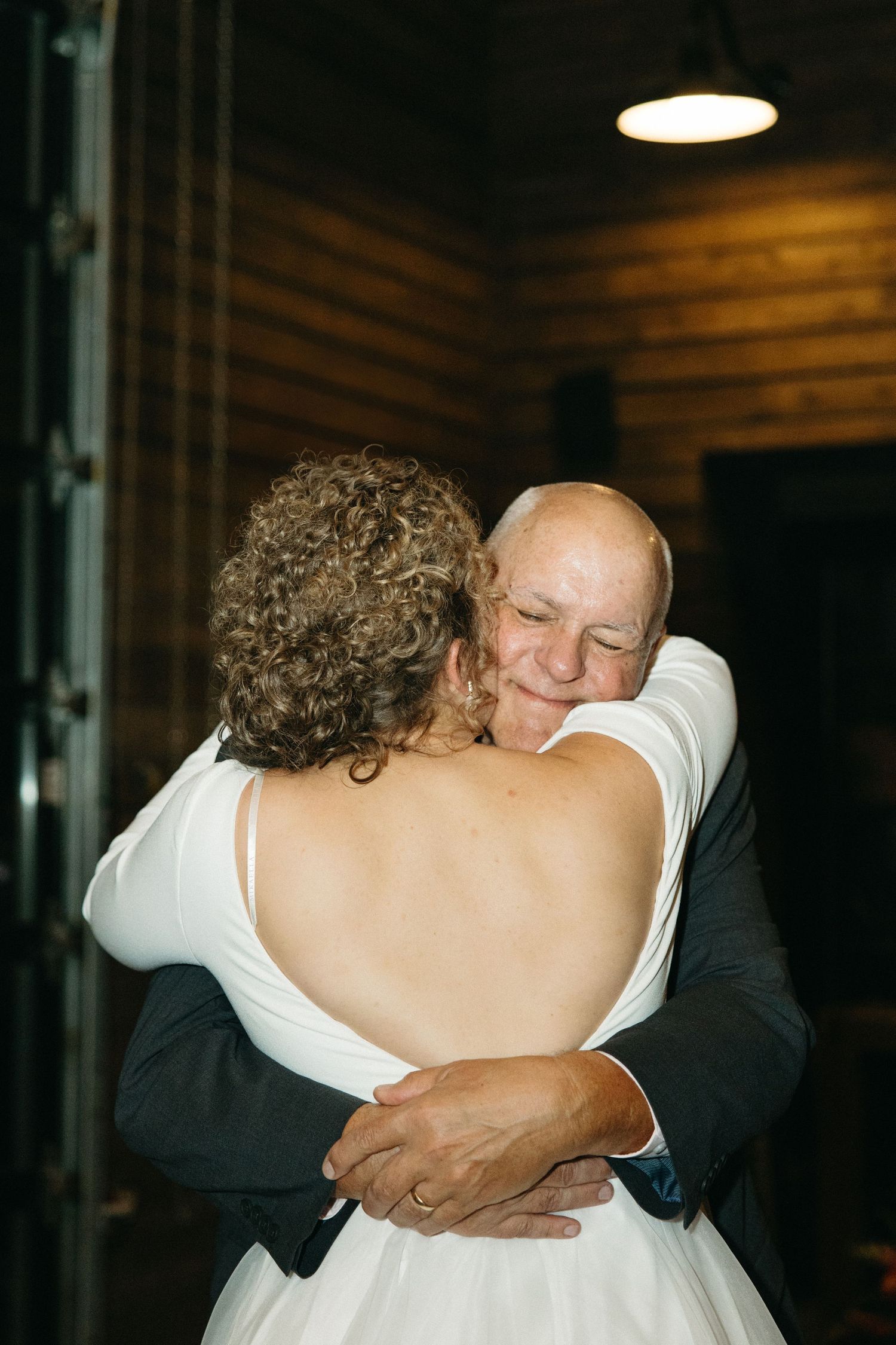 Emotional dance moment between two people at an indoor wedding reception.