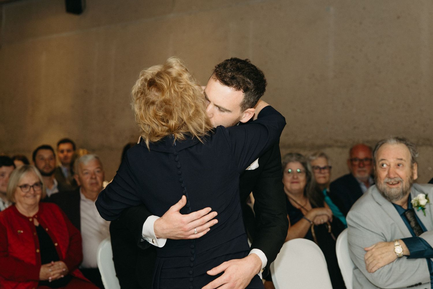 Emotional dance moment between two people at formal event with guests watching.