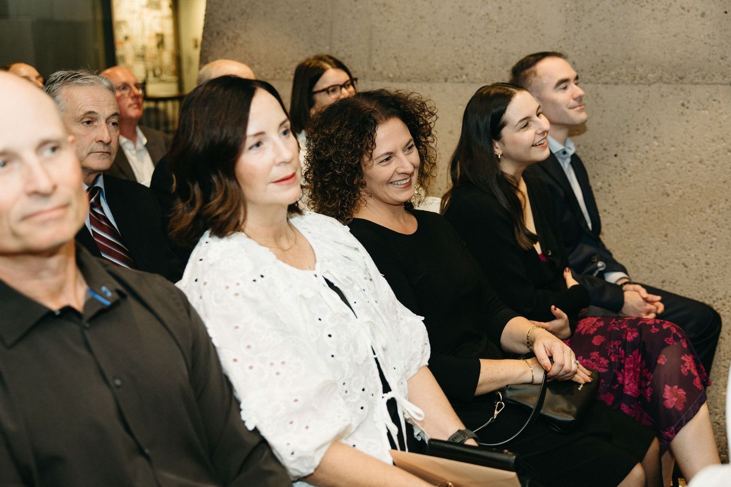 Event attendees seated in rows showing various emotional reactions during a presentation.