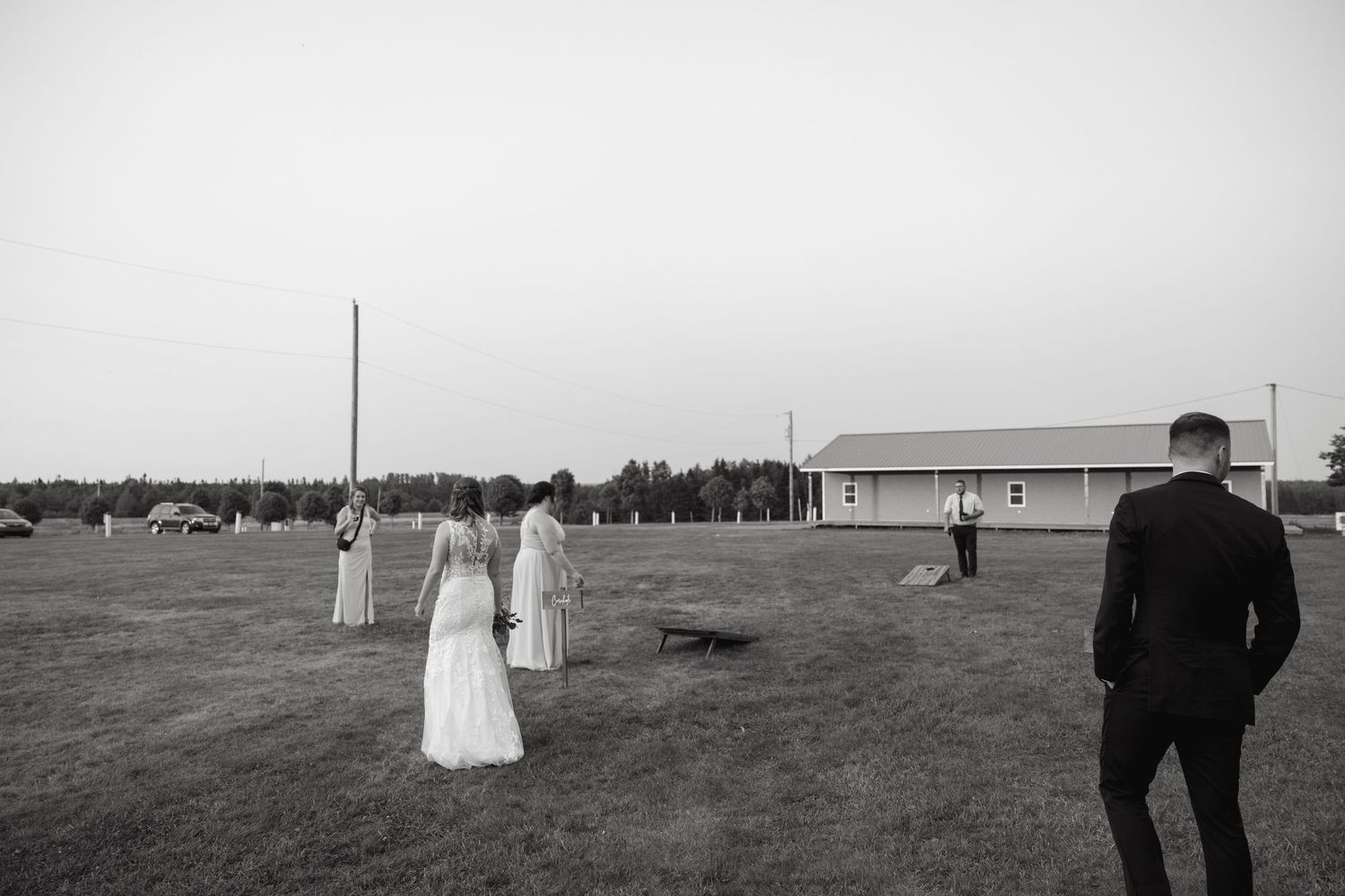 Silhouettes of a couple walking through a vast open field on a cloudy day.