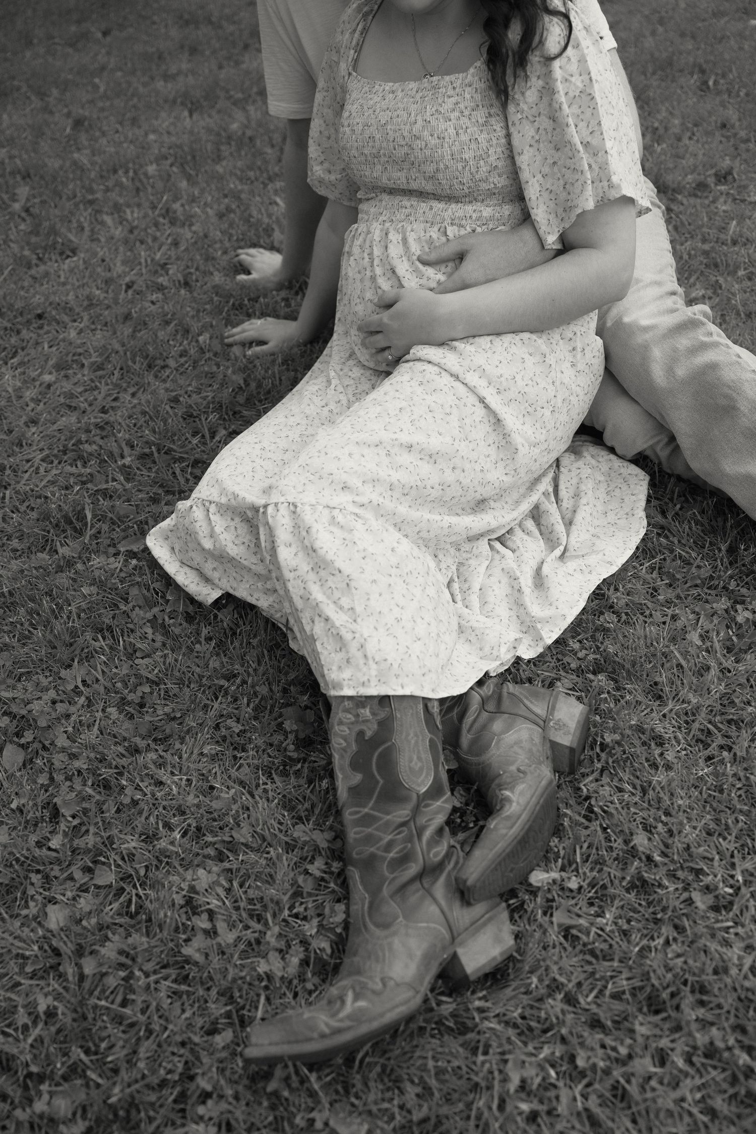 Cowboy boots and a floral dress are shown in a series of black and white close-up photographs.