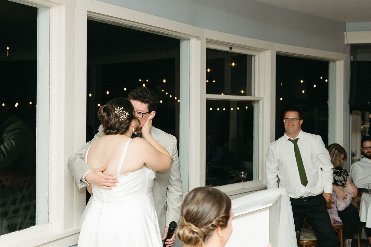 Emotional bride and groom share a tender moment during their first dance at an intimate wedding reception.